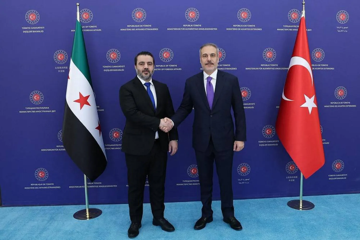 This handout photograph taken and released by the Turkish Foreign Ministry press service shows Turkish Foreign Minister Hakan Fidan (R) meeting with Syrian Foreign Minister Asaad al-Shaibani in Ankara on August 13, 2025. (Handout / Turkish Foreign Ministry / AFP) 