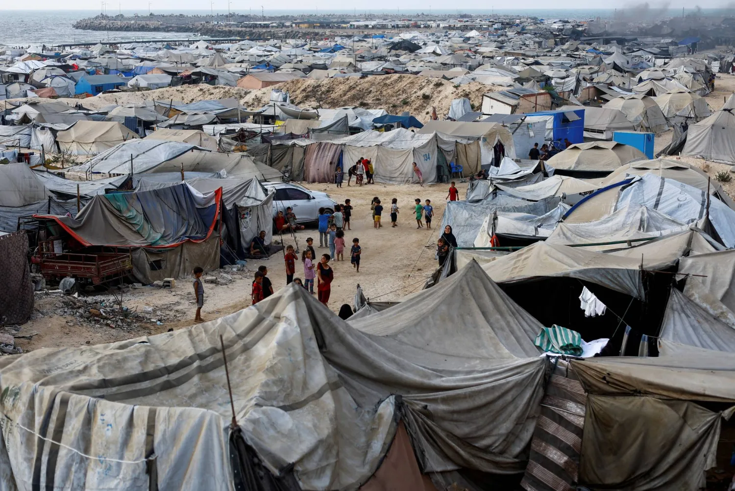 Palestinians, displaced by the Israeli offensive, shelter in a tent camp on a beach amid summer heat in Gaza City, August 12, 2025. REUTERS/Mahmoud Issa