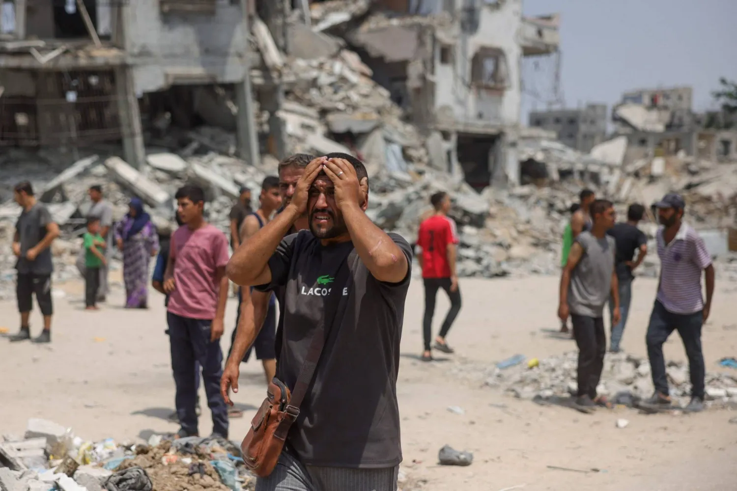 رجل فلسطيني يبكي بينما ينقل المسعفون ضحايا الغارات الإسرائيلية على قطاع غزة (أ.ف.ب)