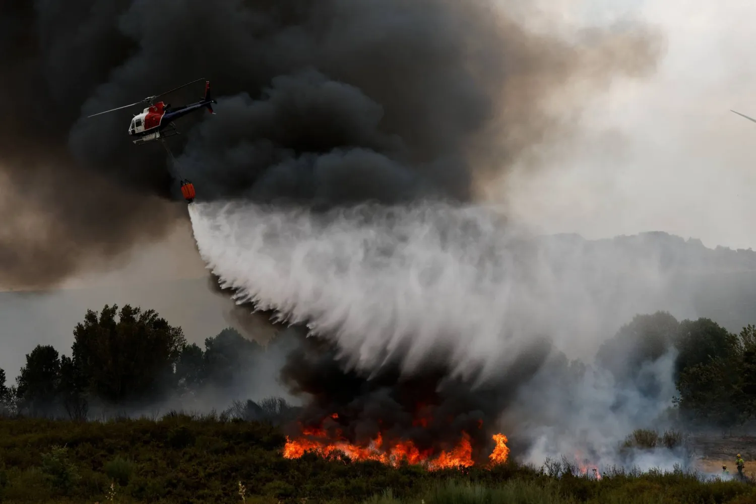 محاولة لإخماد حريق في زامورا الإسبانية (رويترز)