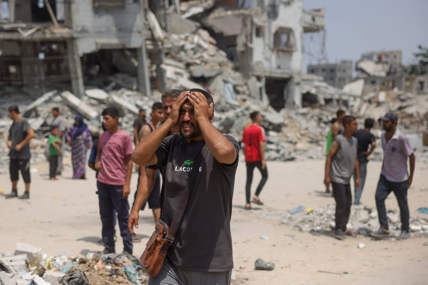 رجل فلسطيني يتفاعل مع قيام المسعفين بنقل ضحايا الغارات الإسرائيلية بالقرب من مركز توزيع المساعدات في شمال قطاع غزة (أ.ف.ب)