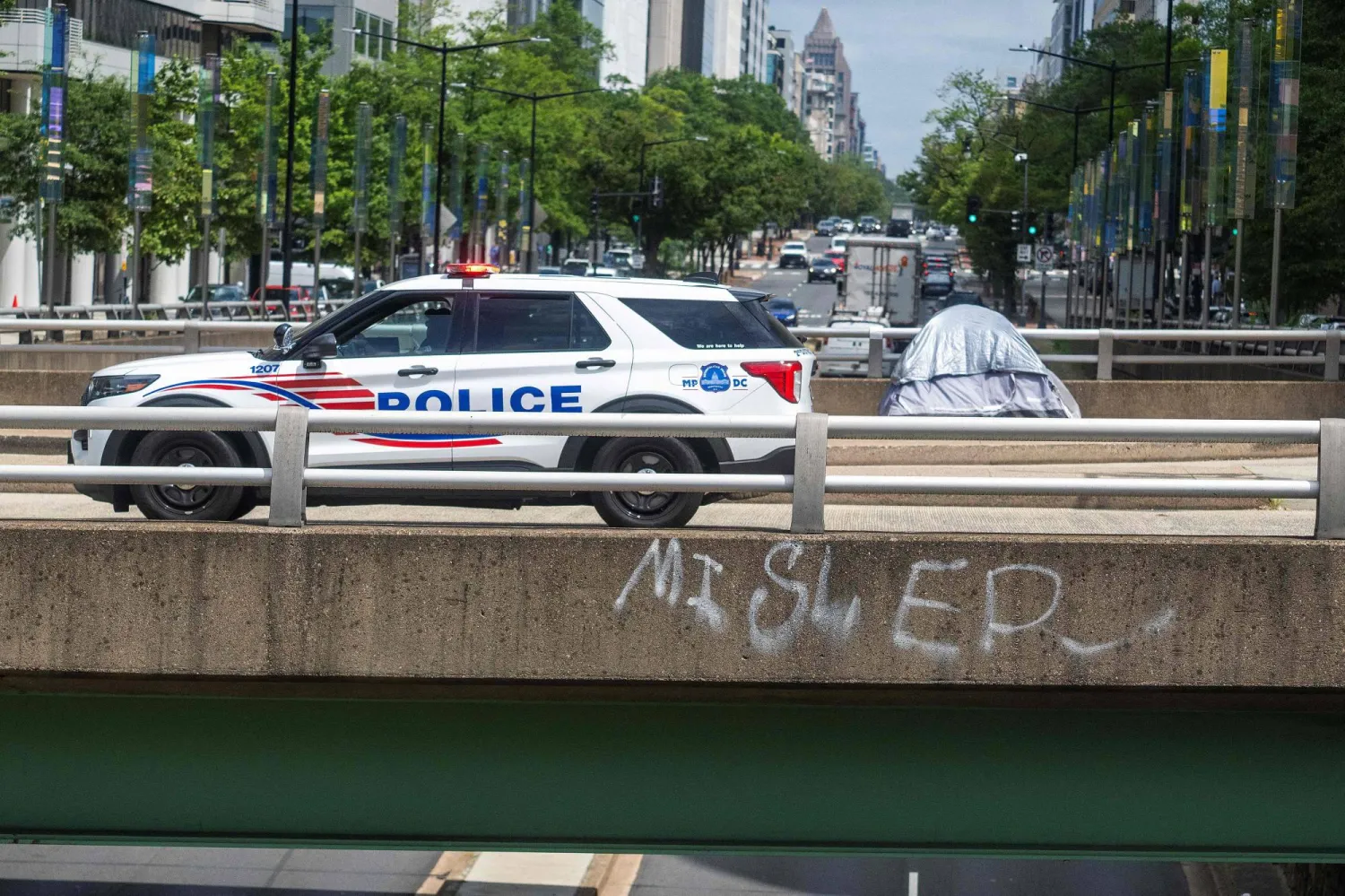 سيارة شرطة تمر بجانب خيمة لمشرّد في واشنطن العاصمة (أ.ف.ب) 