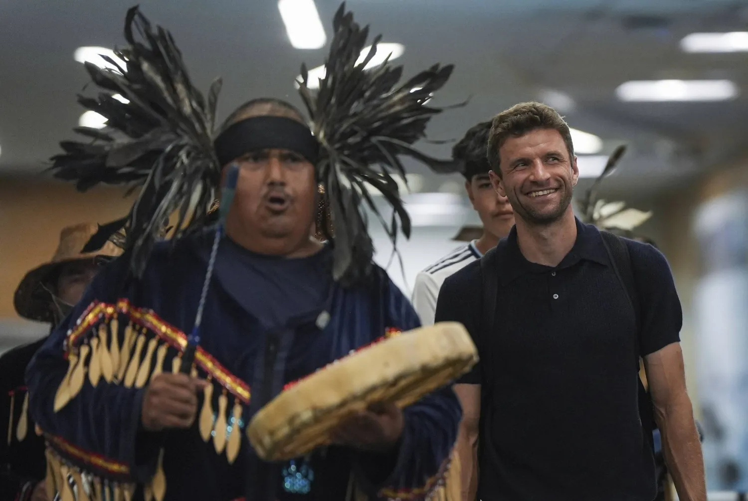 New Vancouver Whitecaps player Thomas Müller walks with members of the Musqueam First Nation as they drum and sing to welcome him, after arriving from Germany at Vancouver International Airport in Richmond, British Columbia, on Wednesday, Aug. 13, 2025. (Darryl Dyck/The Canadian Press via AP)