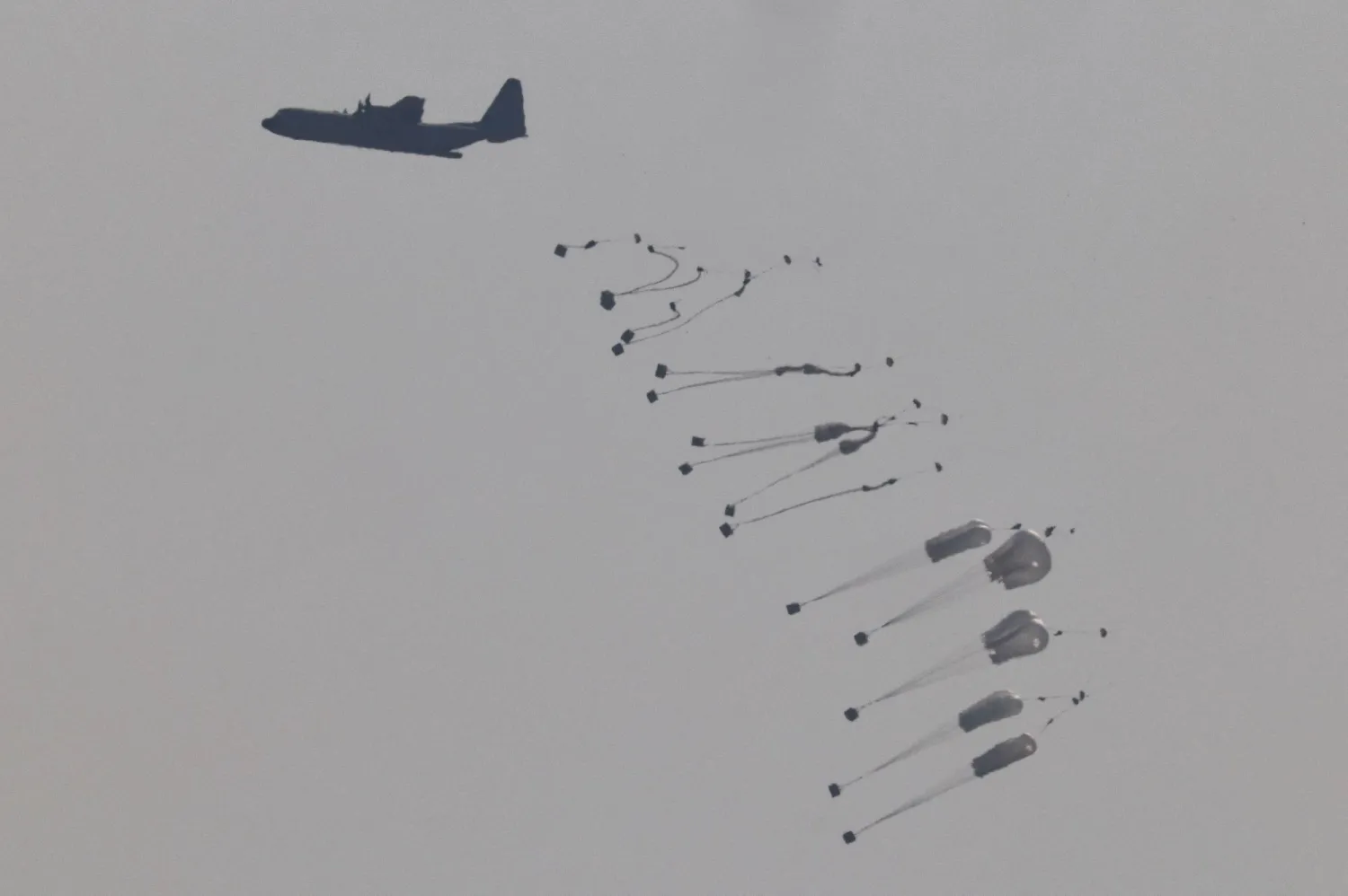 Aid packages dropped from an airplane descend over Gaza Strip, as seen from Israel, August 13, 2025. REUTERS/Amir Cohen