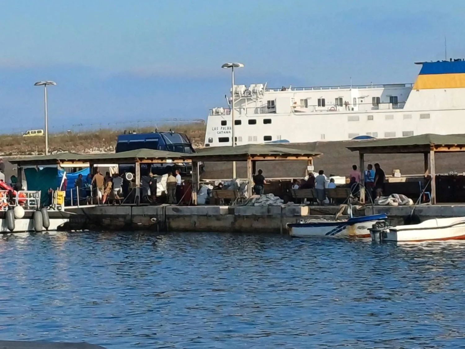Migrants disembark from the boat that rescued them after their ship sank off the coast of Italy's Lampedusa island in the harbor of Italian island of Lampedusa on August 14, 2025. (Photo by -STR / ANSA / AFP) / Italy OUT
