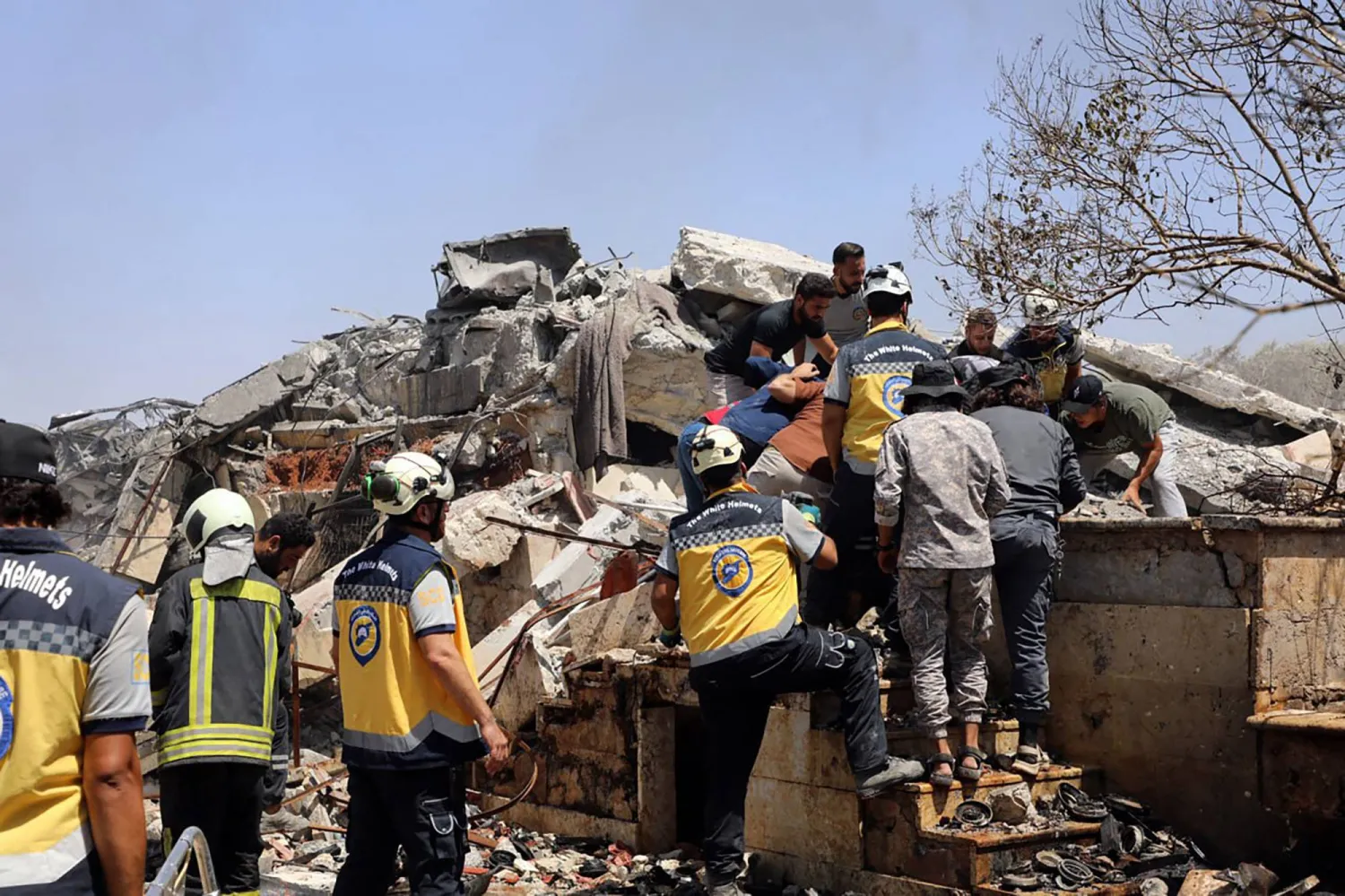 فرق الإنقاذ تخلي الضحايا من وسط الأنقاض بعد انفجار هز إدلب يوم 14 أغسطس 2025 (أ.ف.ب)