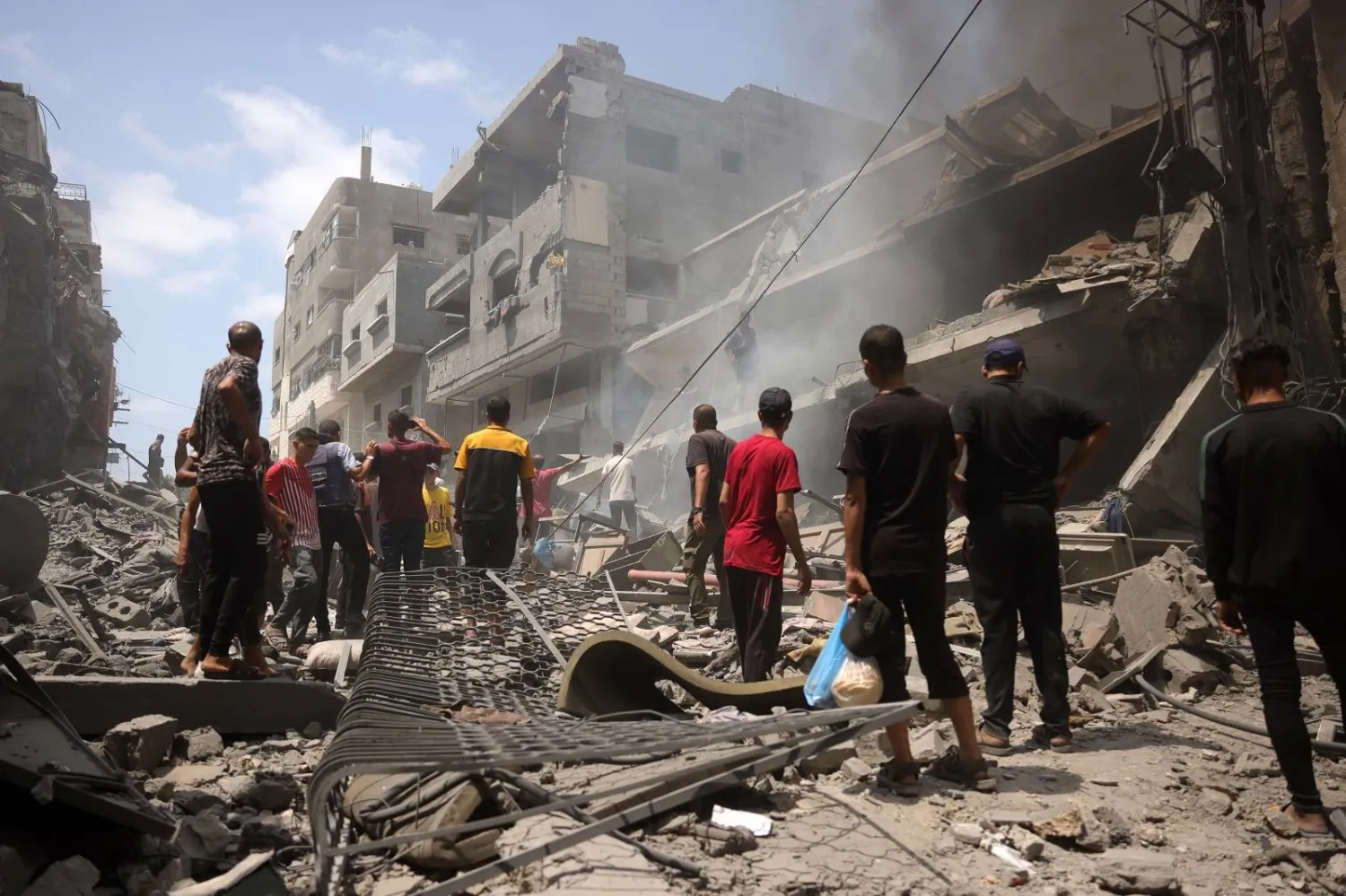 فلسطينيون يتفقدون الدمار الذي خلفته غارة إسرائيلية استهدفت حي الزيتون جنوب مدينة غزة (أ.ف.ب)