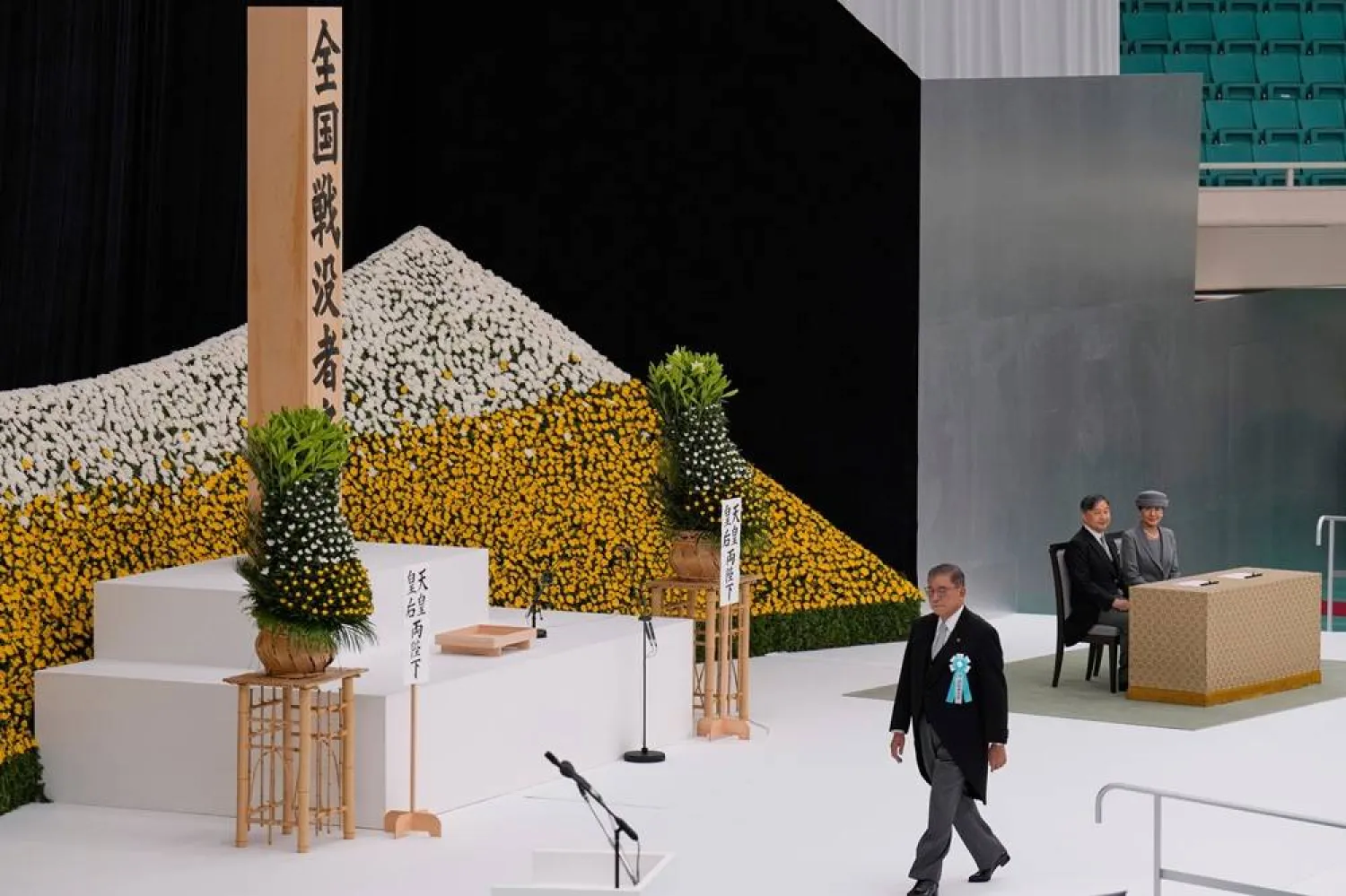  Japan's Prime Minister Shigeru Ishiba, left, walks to deliver a speech as Japan's Emperor Naruhito and Empress Masako attend a memorial service marking the 80th anniversary of Japan's World War II defeat, at the Nippon Budokan hall Friday, Aug. 15, 2025, in Tokyo. (AP)