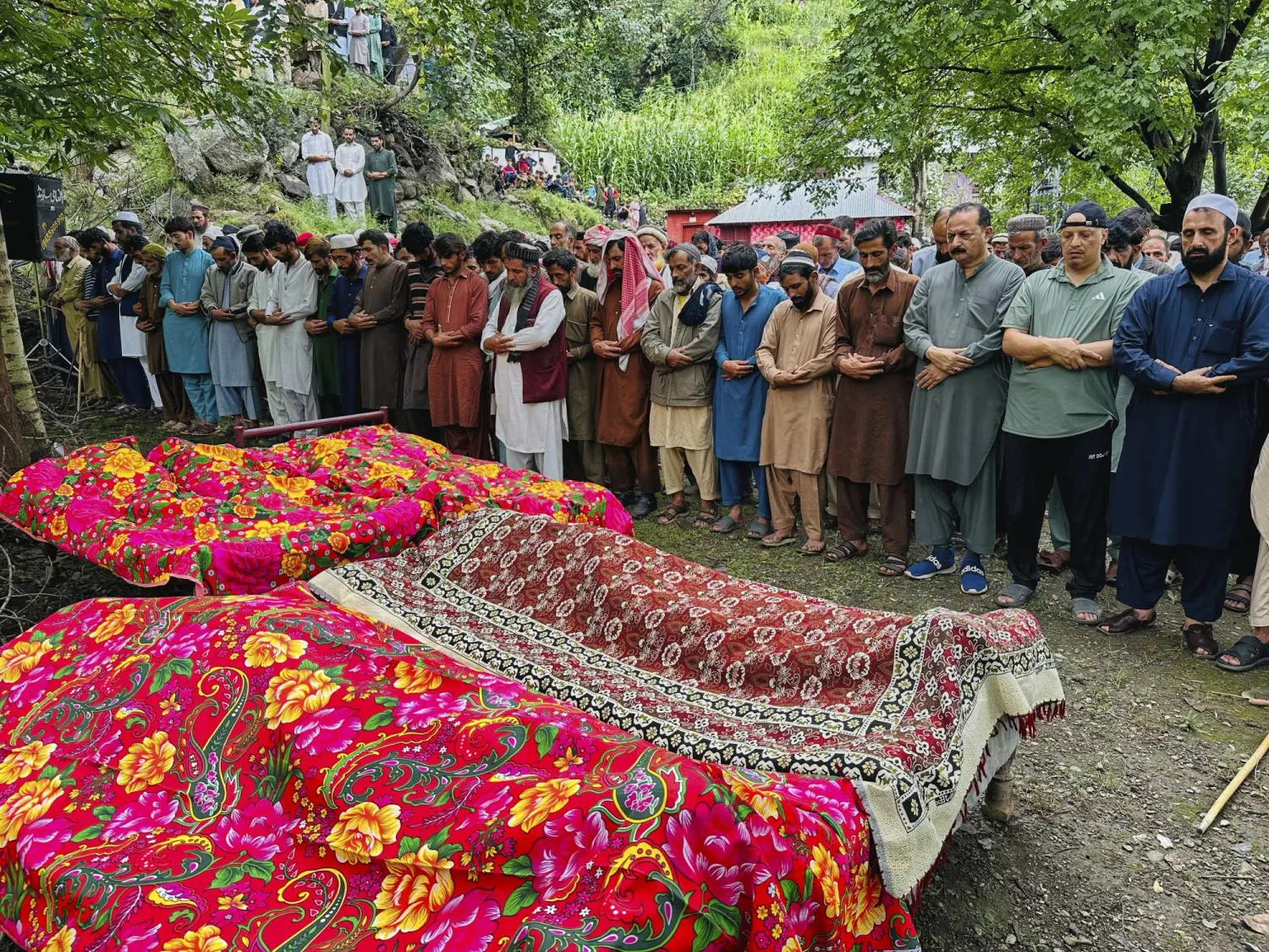 يشارك الناس في صلاة الجنازة على ضحايا حادث هطول أمطار غزيرة مفاجئة بقرية ناريان بيهاك بالقرب من مظفر آباد المدينة الرئيسية في الجزء الخاضع لسيطرة باكستان من كشمير اليوم الجمعة (أ.ب)