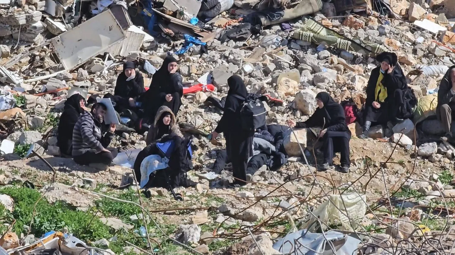 لبنانيات يفترشن الأرض على ركام منازلهن المدمرة في ميس الجبل بجنوب لبنان (الشرق الأوسط)