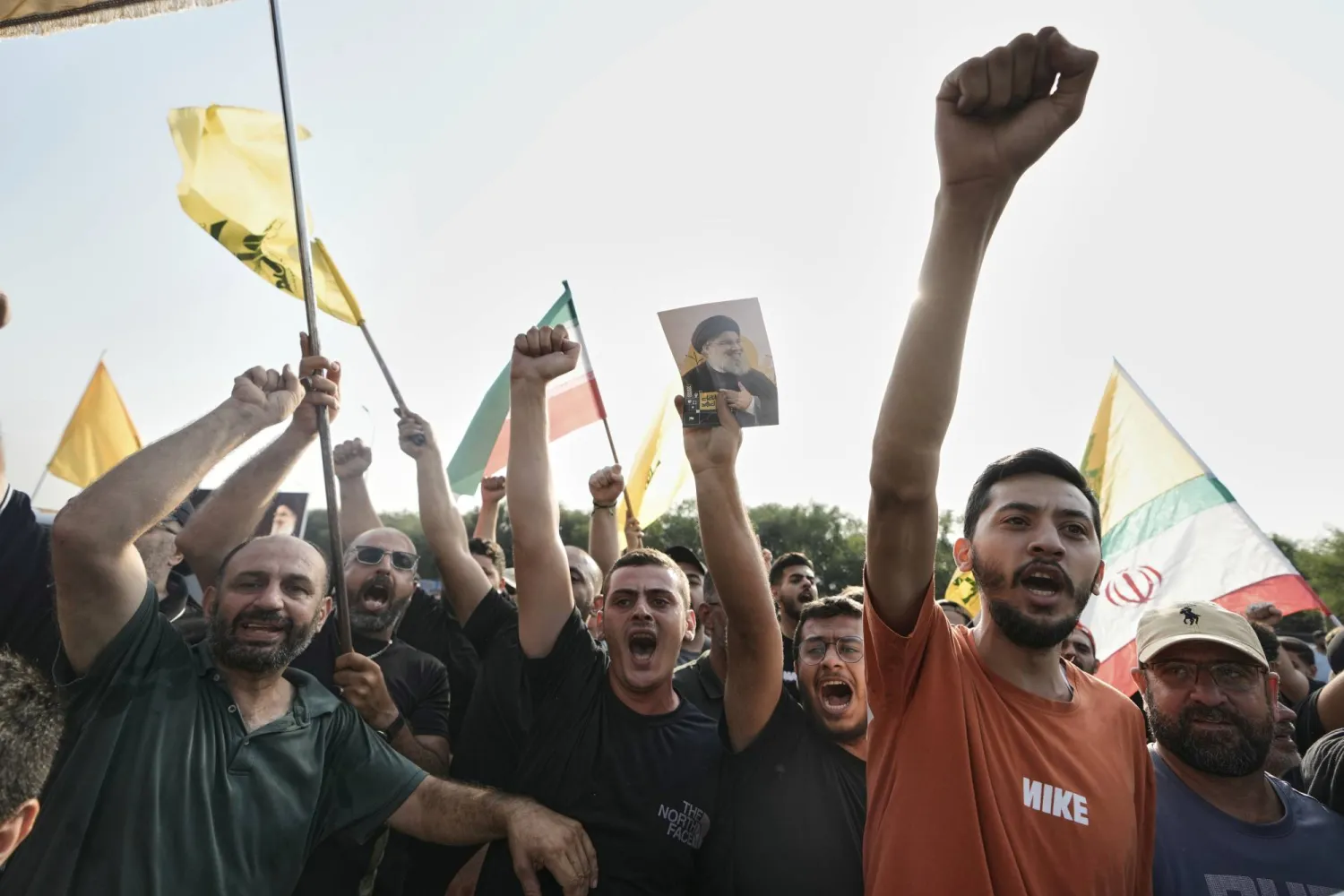 مناصرون لـ«حزب الله» يرفعون قبضاتهم خلال استقبال لاريجاني قرب مطار بيروت الأربعاء (أ.ب)