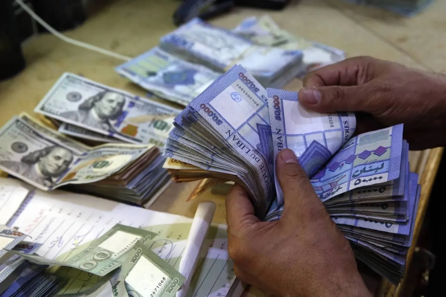 A man counts Lebanese pounds at an exchange shop in Beirut, Lebanon, August 20, 2018 (File – AP) 