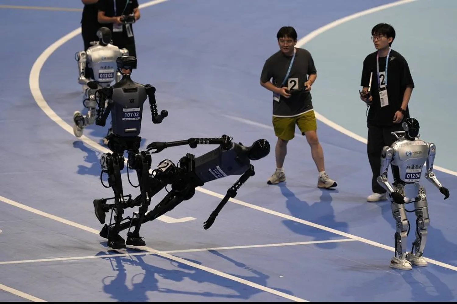  A robot falls after tagging off to the last leg of its team in the 4x100m final at the World Humanoid Robot Games held in Beijing, China, Sunday, Aug. 17, 2025. (AP) 