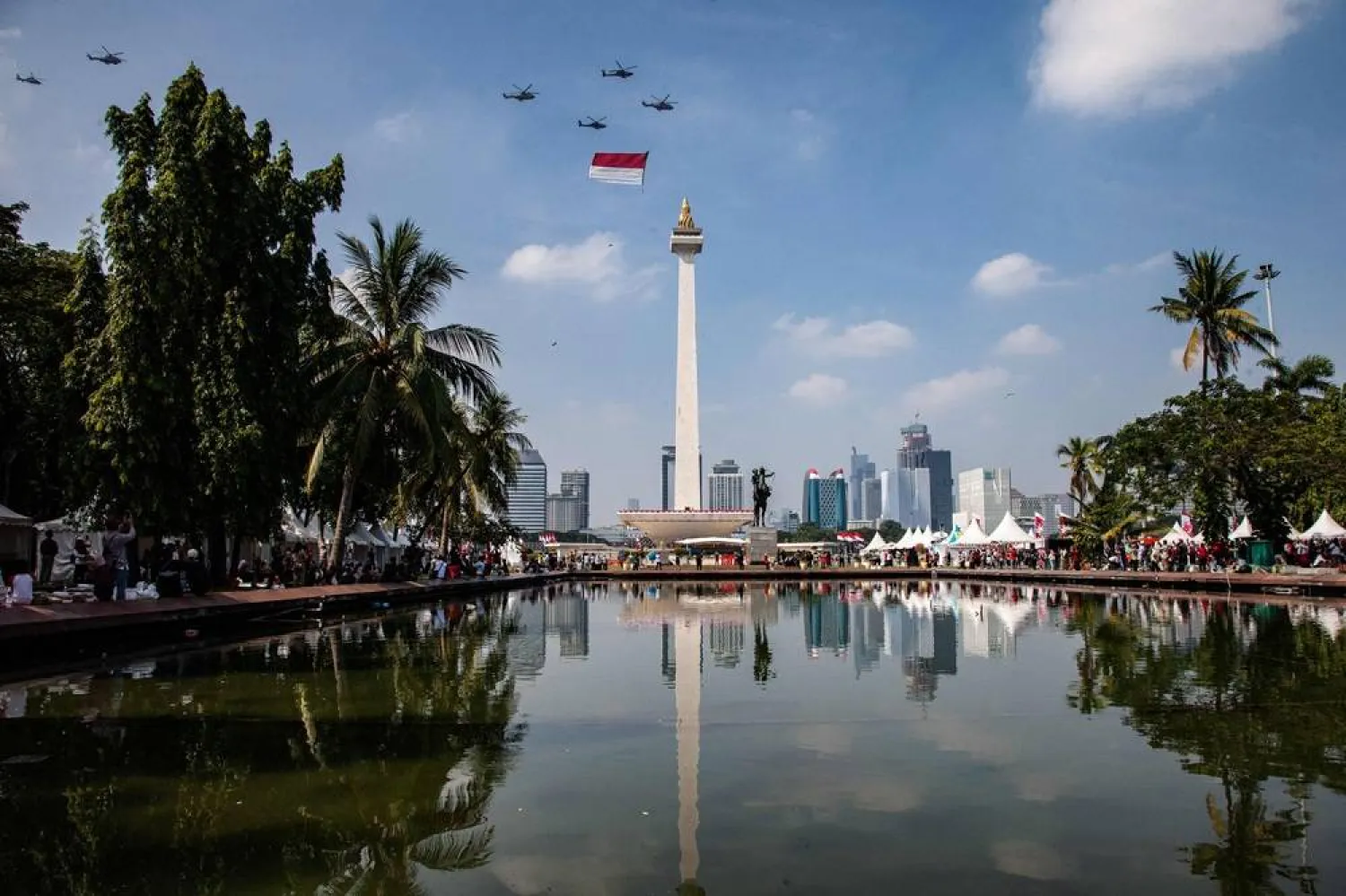 An Indonesian Armed Forces helicopter performs a flypast carrying the national flag over the National Monument (Monas) during the commemoration of Indonesia’s 80th Independence Day in Jakarta on August 17, 2025. (AFP) 