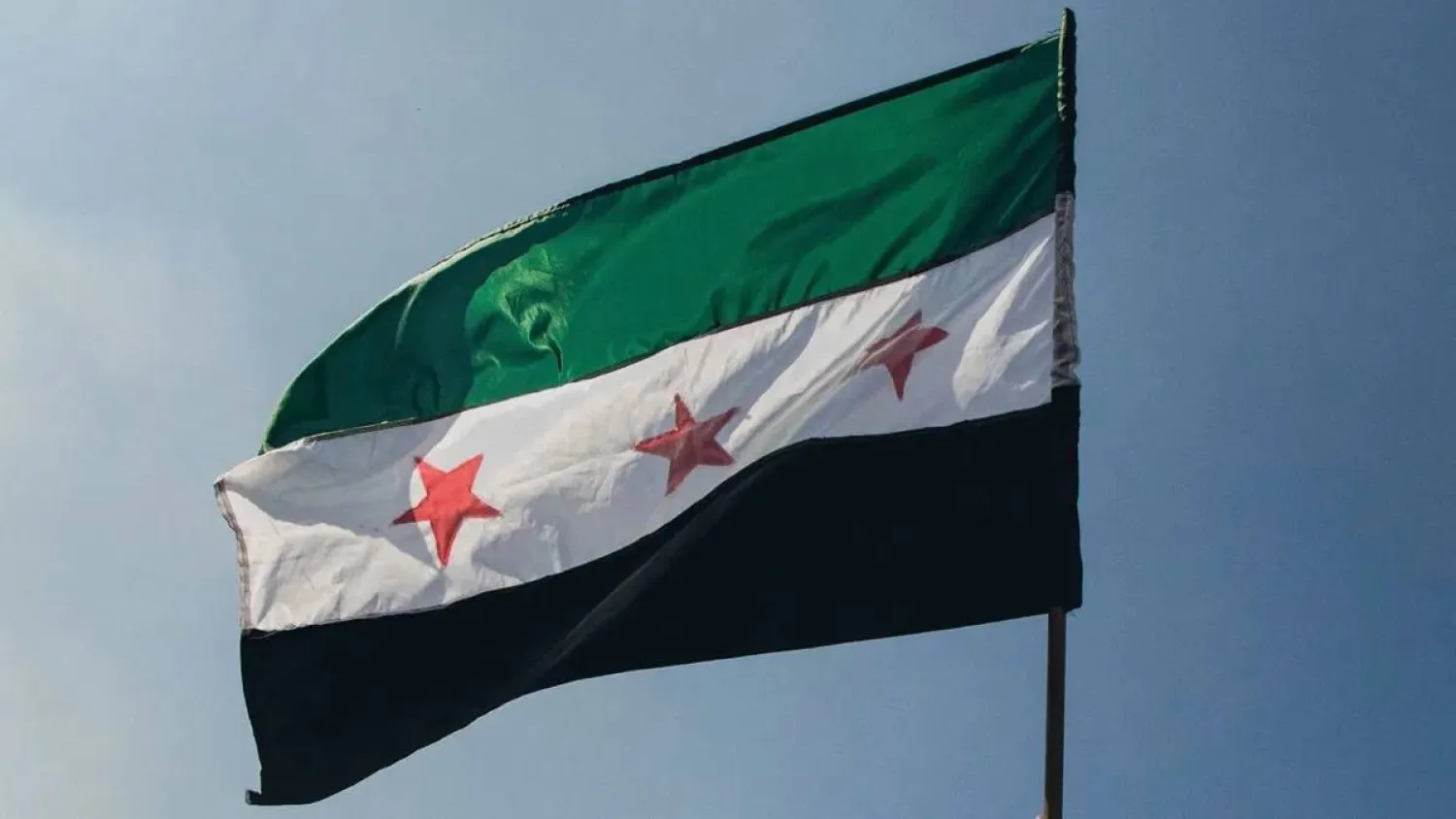 A Syrian flag is waved in Damascus. (AFP/Getty Images)