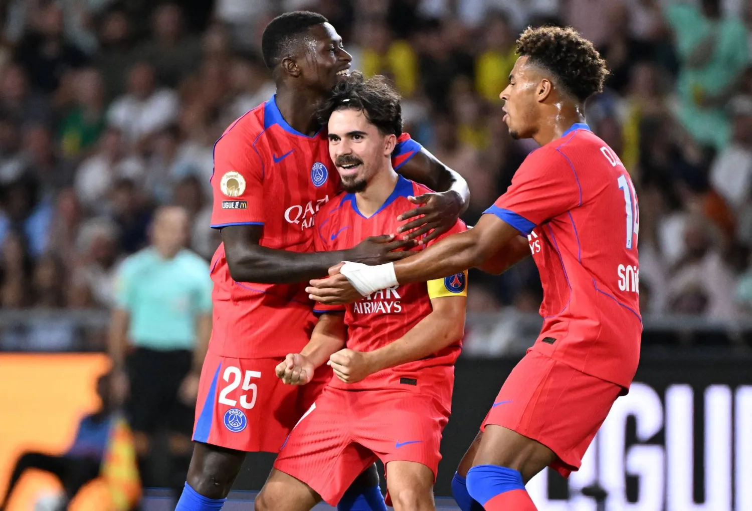 Paris Saint-Germain's Portuguese midfielder #17 Vitinha (C) celebrates with Paris Saint-Germain's Portuguese defender #25 Nuno Mendes (L) and Paris Saint-Germain's French midfielder #14 Desire Doue (R) after scoring Paris Saint-Germain's first goal during the French L1 football match between FC Nantes and Paris Saint-Germain (PSG) in Nantes, western France, on August 17, 2025. (Photo by Sebastien Salom-Gomis / AFP)