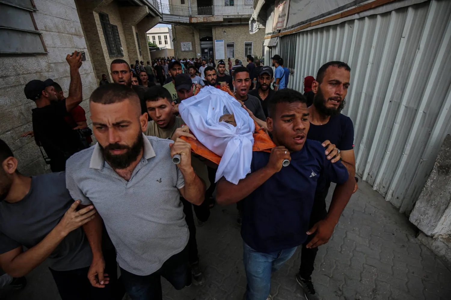 أشخاص يحملون جثامين فلسطينيين قُتلوا في غارة إسرائيلية على مدينة غزة أمس (د.ب.أ)