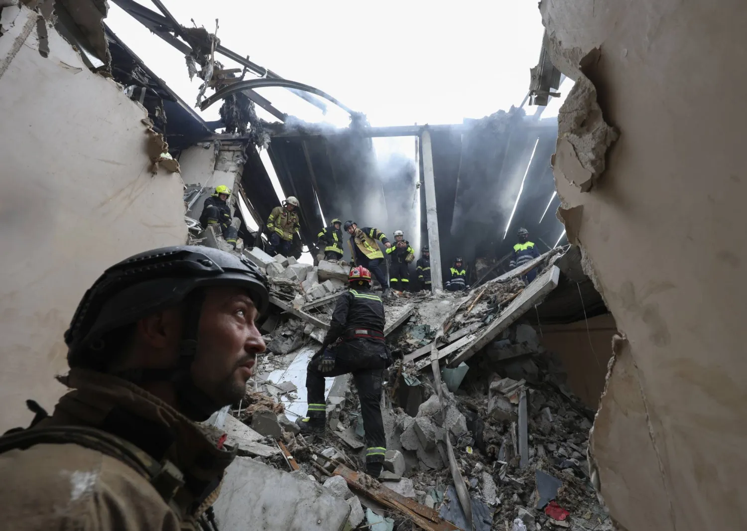 رجال إنقاذ أوكرانيون يعملون في موقع غارة جوية بطائرة مسيّرة على منطقة سكنية في خاركيف شمال شرقي أوكرانيا (إ.ب.أ)