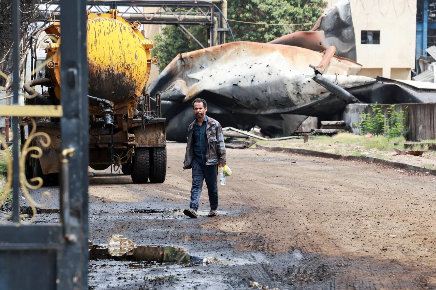عامل يسير في محطة كهرباء حزيز بصنعاء بعد تعرضها لهجوم صاروخي إسرائيلي (رويترز)