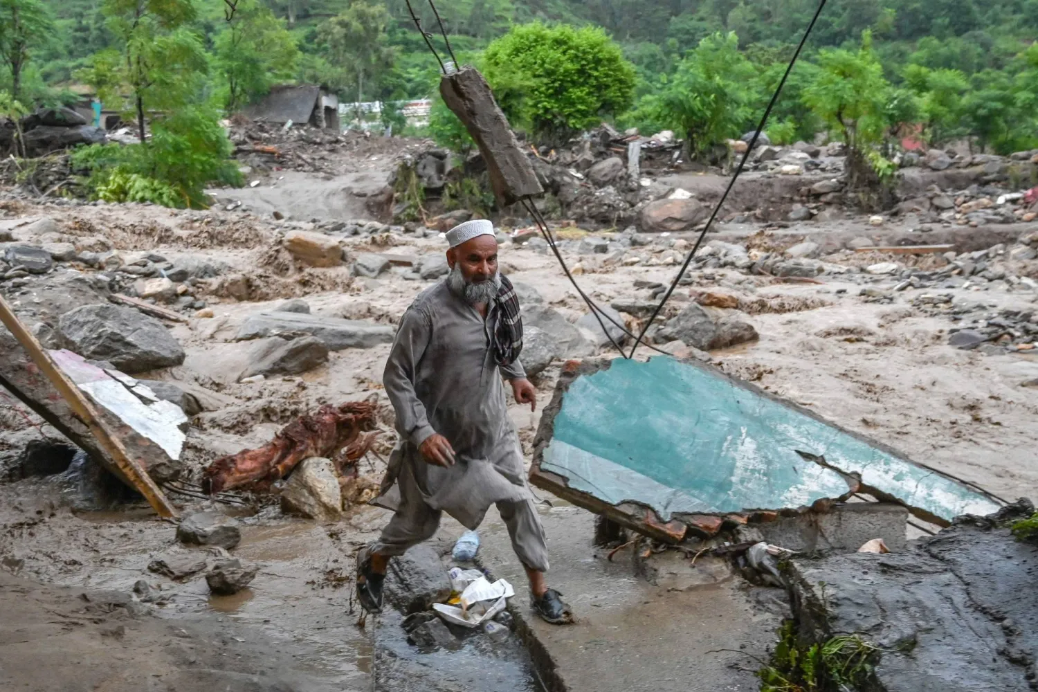 أدت الأمطار التي هطلت فجأة في منطقة سوابي إلى انهيار أسقف المنازل وتشكُّل سيول من الطين جرفت ما كان في طريقها (أ.ف.ب)