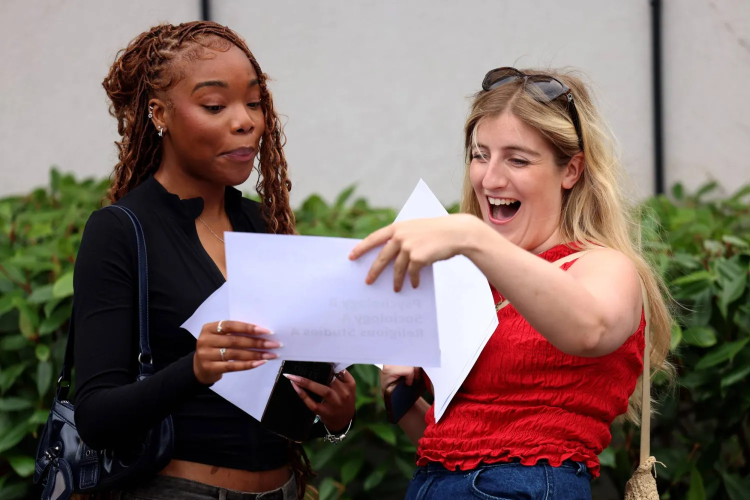 طالبتان تتسلمان نتائج امتحانات المستوى المتقدم في مدرسة جنوب لندن (إ.ب.أ)