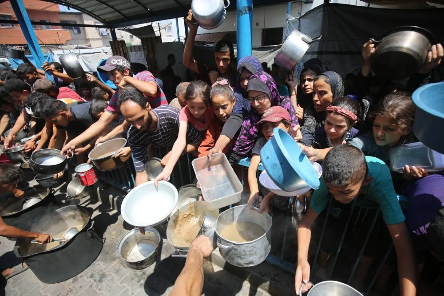 18 August 2025, Palestinian Territories, Gaza City: Palestinians wait to receive food from a charity kitchen, amid a hunger crisis due to the Israeli bombing and blockade on Gaza. (dpa) 