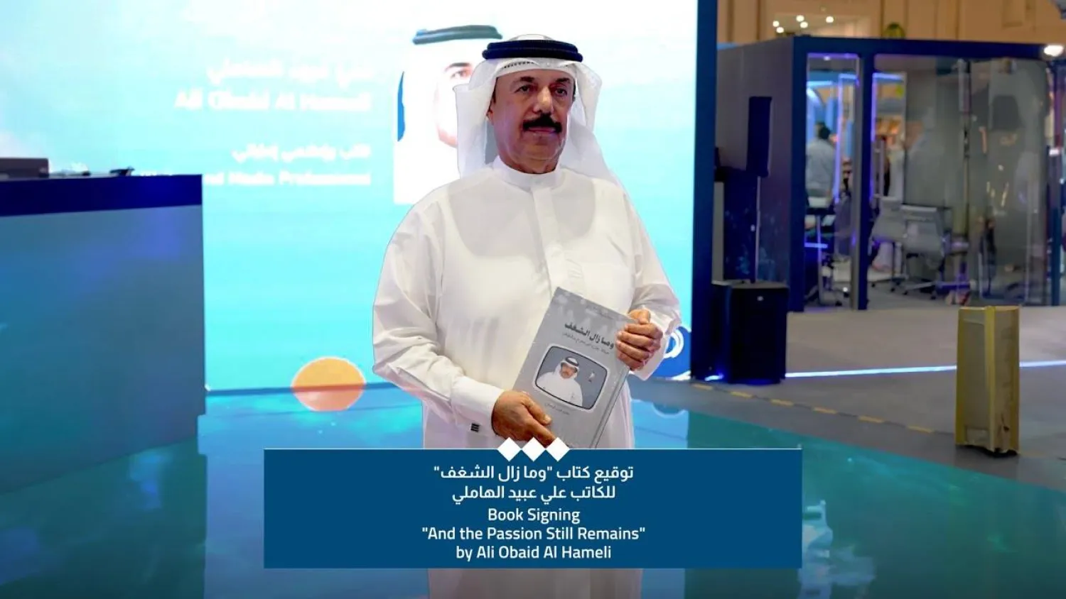 علي عبيد الهاملي مع غلاف كتابه الجديد