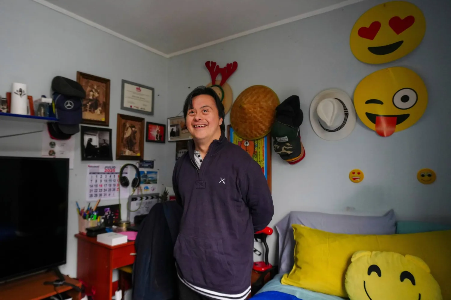 الممثل سيباستيان سولورزا الذي يعاني من «متلازمة داون» ويسعى للترشح للرئاسة مرشحاً مستقلاً يبتسم خلال مقابلة في منزله بسانتياغو (أ.ب)