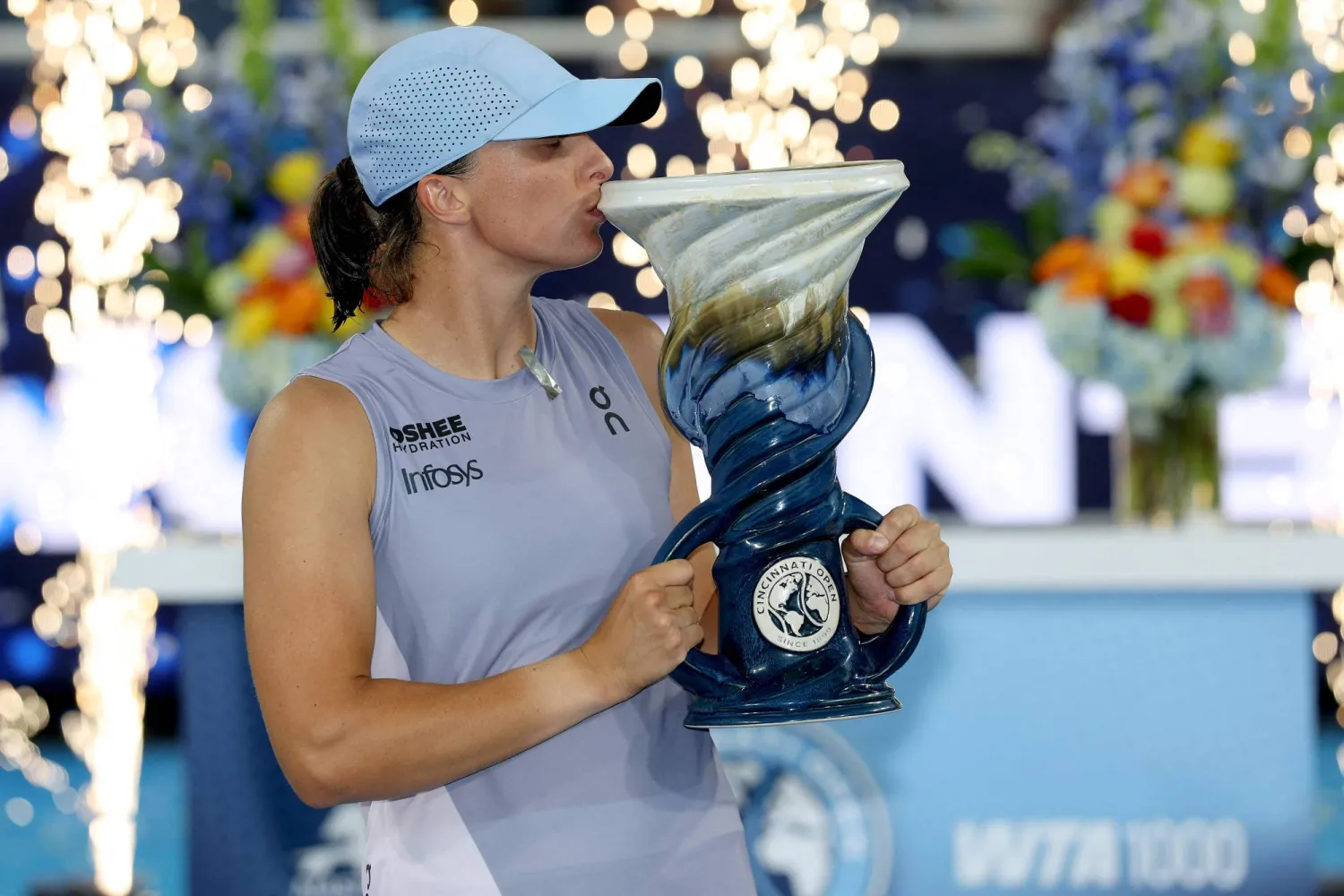 النجمة البولندية تقبّل الكأس عقب فوزها على باوليني (أ.ف.ب)