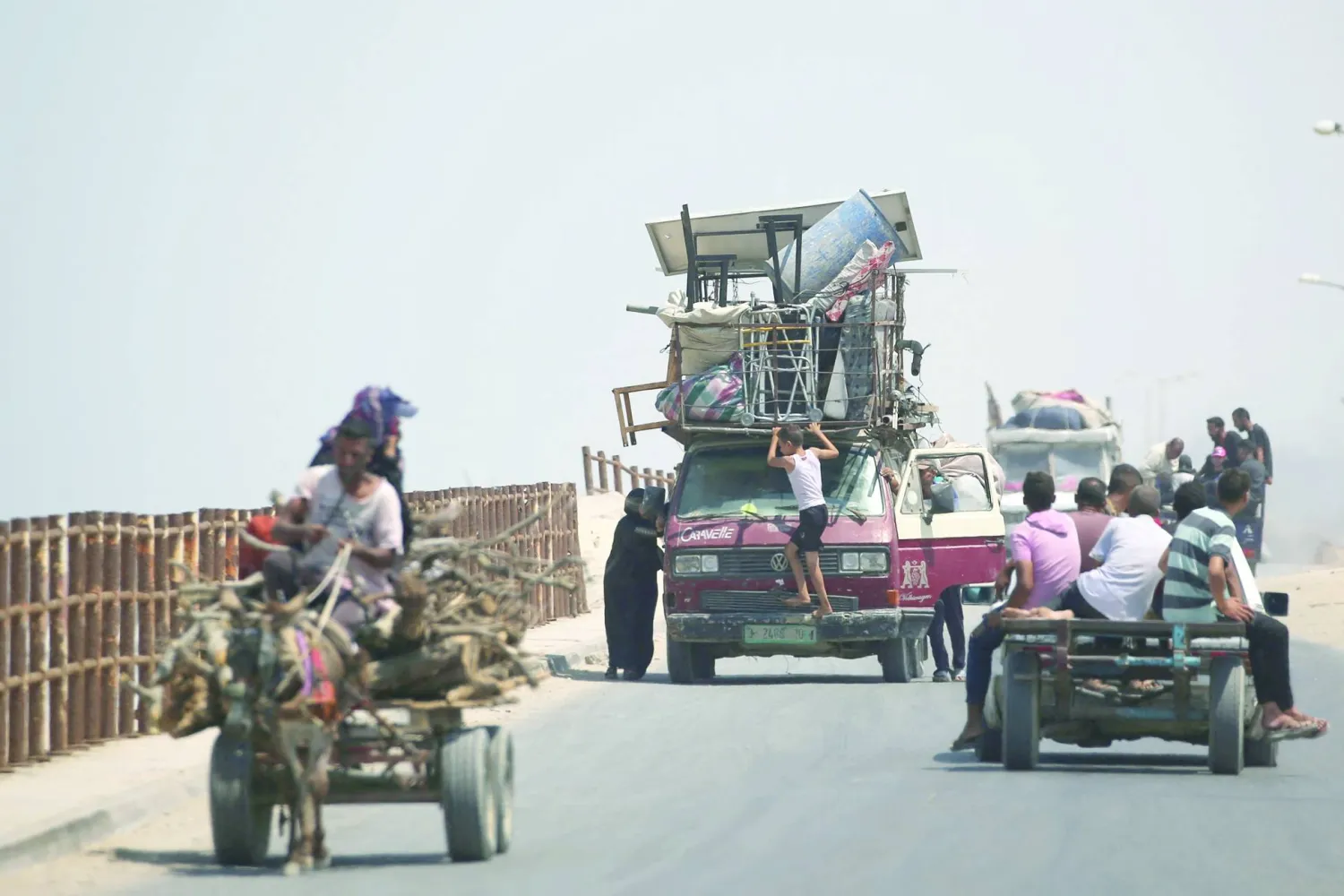 Palestinian families arrive with their belongings in the Nuseirat in the central Gaza Strip on August 18, 2025, as they flee their homes in Gaza City heading toward the south. (Photo by Eyad BABA / AFP)
