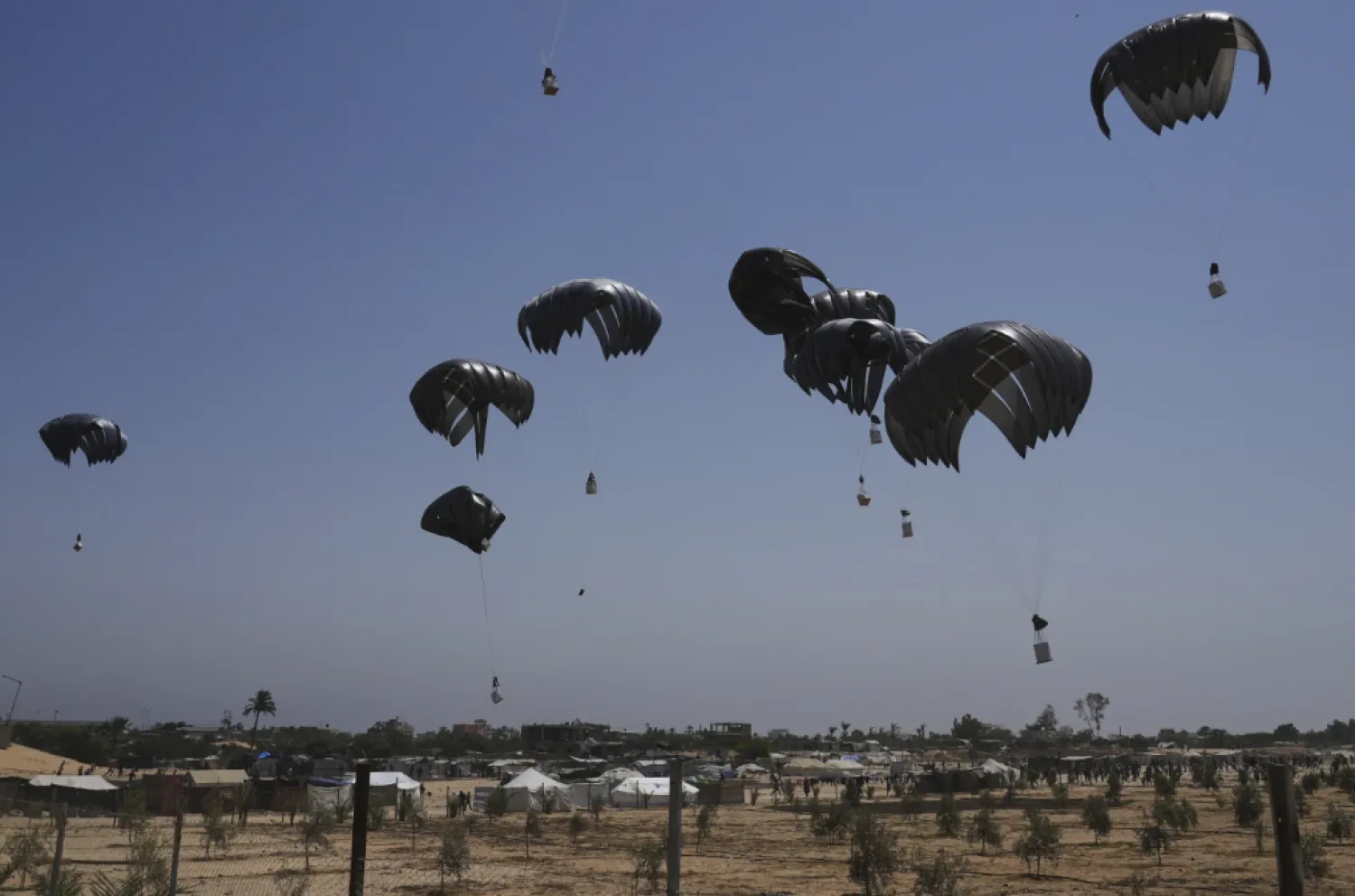  Parachutes drop supplies into Deir al-Balah, central Gaza Strip, Tuesday, Aug. 19, 2025. (AP Photo/Abdel Kareem Hana)

