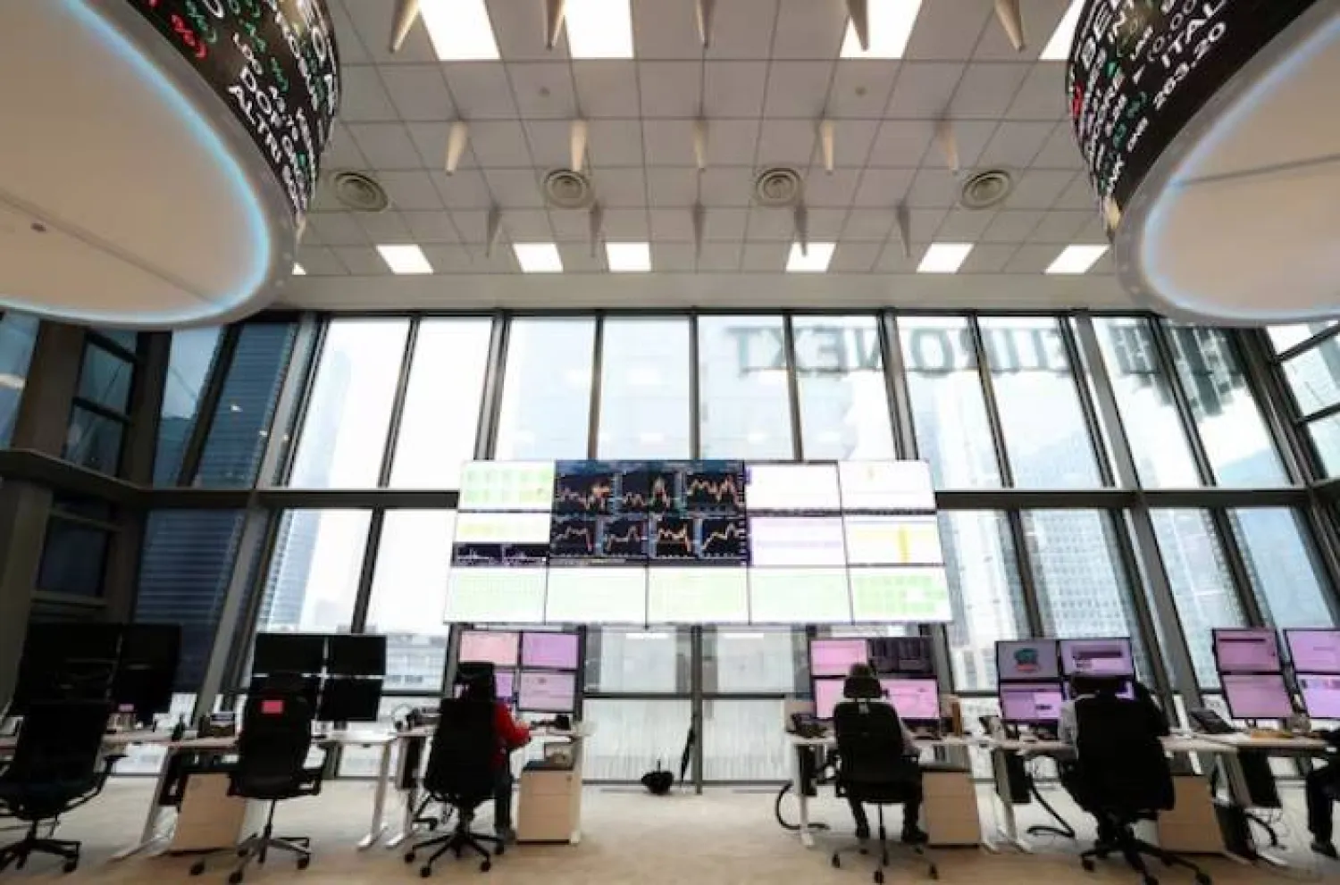 أشخاص يعملون في قاعة التداول لبورصة يورونكست بمنطقة الأعمال لا ديفانس في باريس (رويترز)