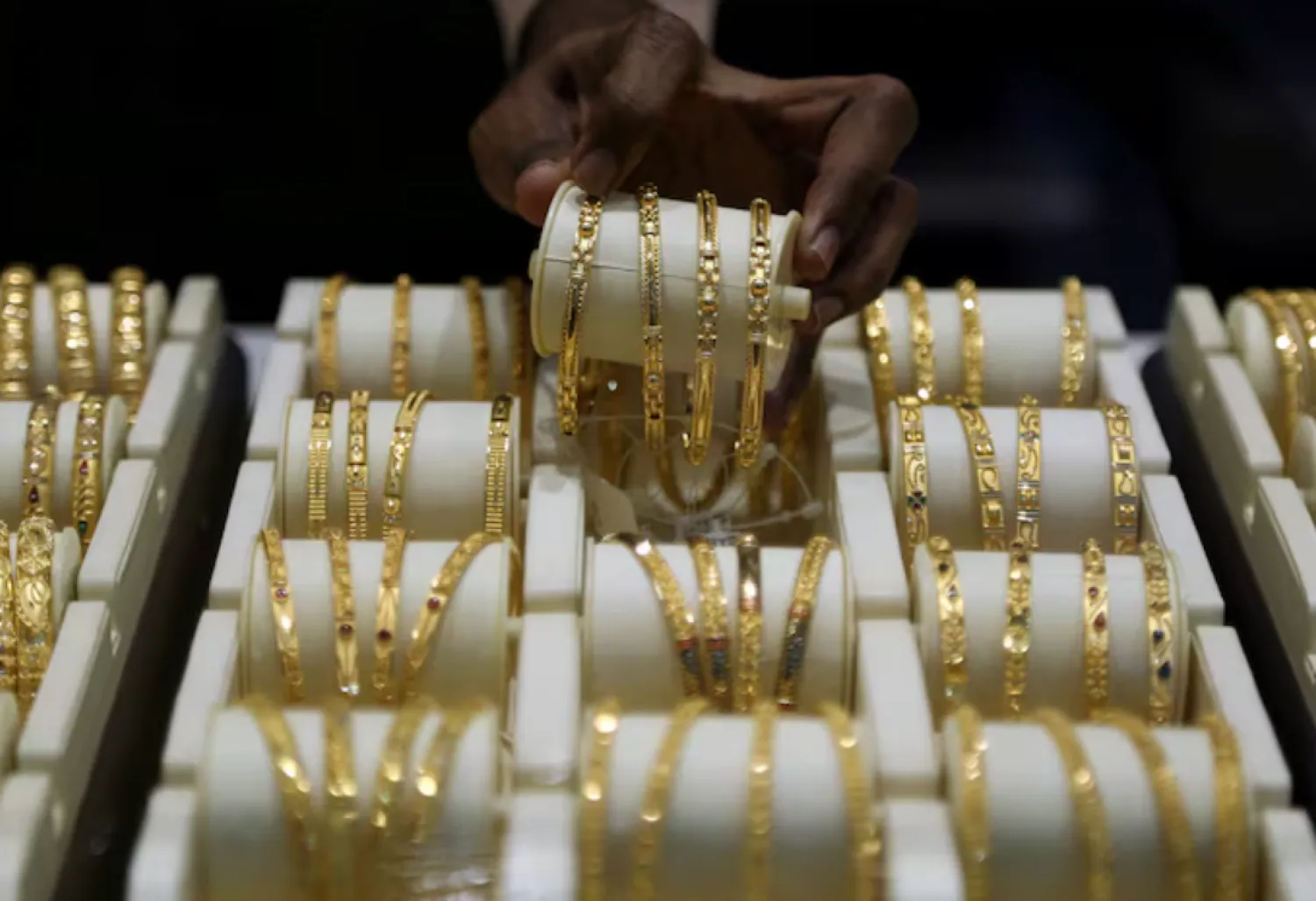 A salesman arranges gold bangles inside a jewellery showroom on the occasion of Akshaya Tritiya, a major gold buying festival, in Mumbai, India, May 7, 2019. REUTERS/Francis Mascarenhas/File Photo 
