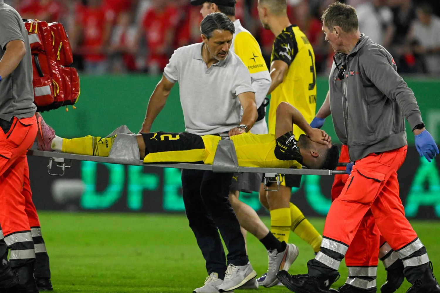 مدافع دورتموند يان كوتو يخرج من الملعب على محفة بعد إصابته (أ.ف.ب) 