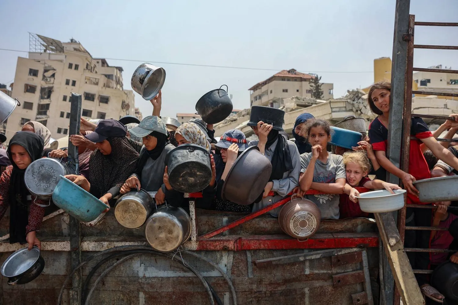 فلسطينيون يتجمعون لاستلام وجبات طعام مطبوخة من مركز توزيع أغذية في مدينة غزة (أ.ف.ب)