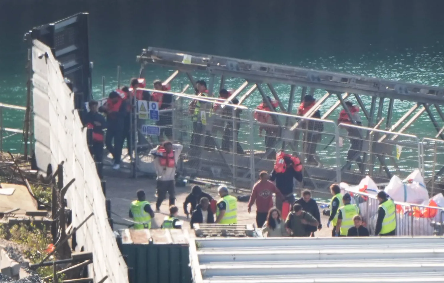 صورة ملتقطة في 15 أغسطس 2025 في دوفر ببريطانيا تظهر نقل مجموعة من الأشخاص يُعتقد أنهم مهاجرون إلى مجمع قوة الحدود (د.ب.أ)