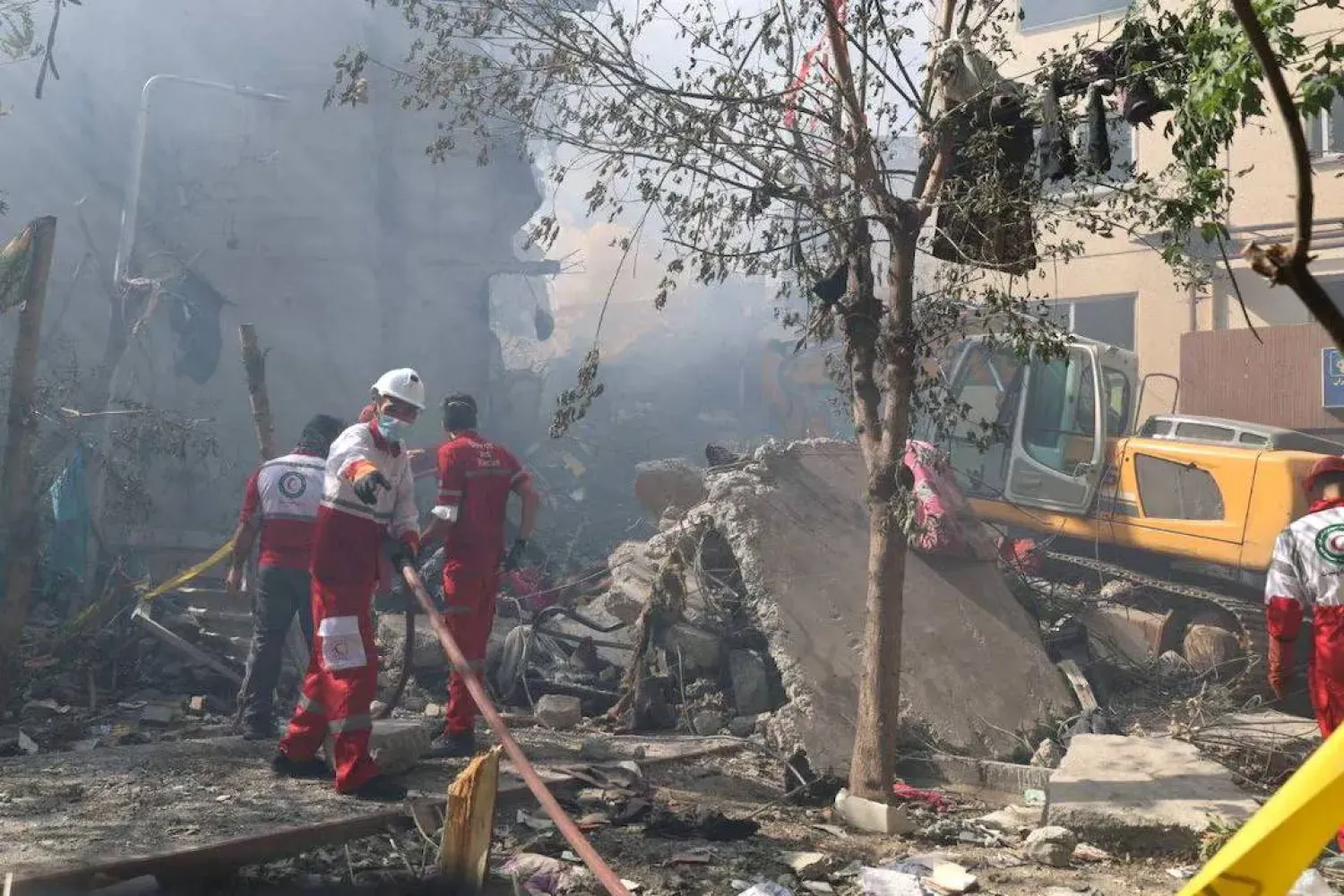 Kurtarma ekipleri, 13 Haziran 2025'te İran'ın başkenti Tahran'a düzenlenen İsrail saldırıları sonrasında hasar gören bir binada çalışıyor (Reuters)