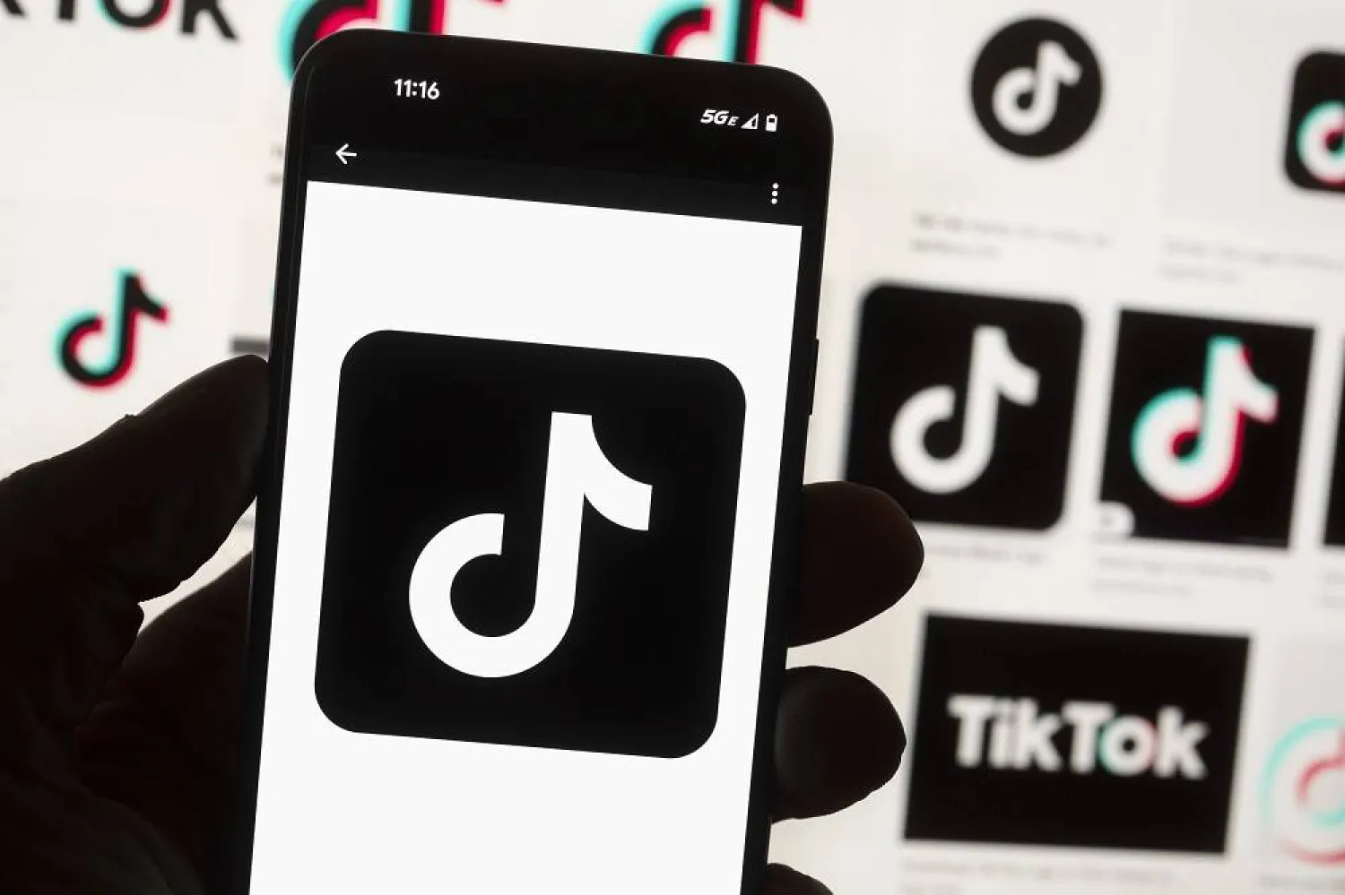 The TikTok logo is seen on a mobile phone in front of a computer screen which displays the TikTok home screen, Oct. 14, 2022, in Boston. (AP)