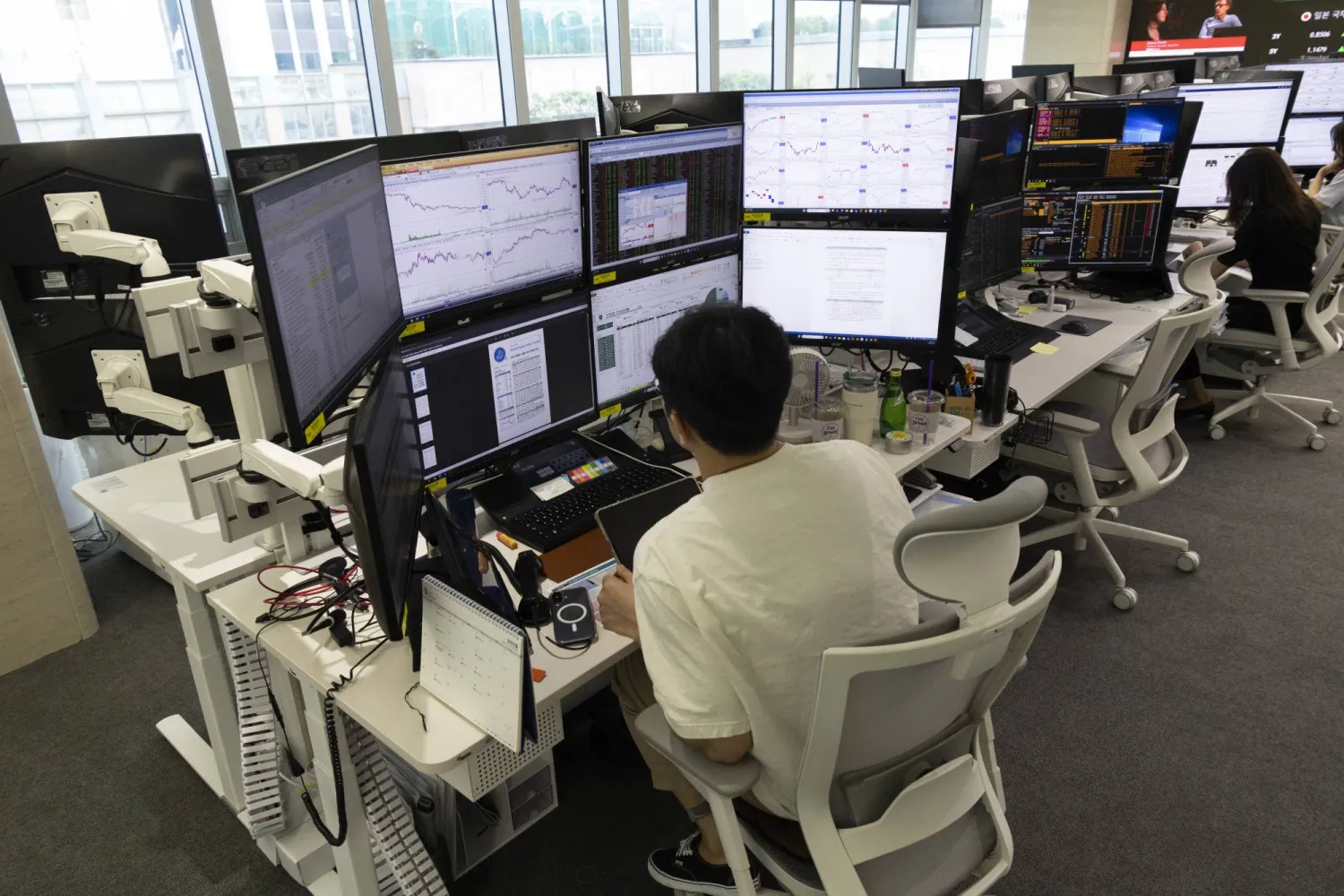 متداول يراقب شاشات الأسهم في بنك هانا بسيول (إ.ب.أ)