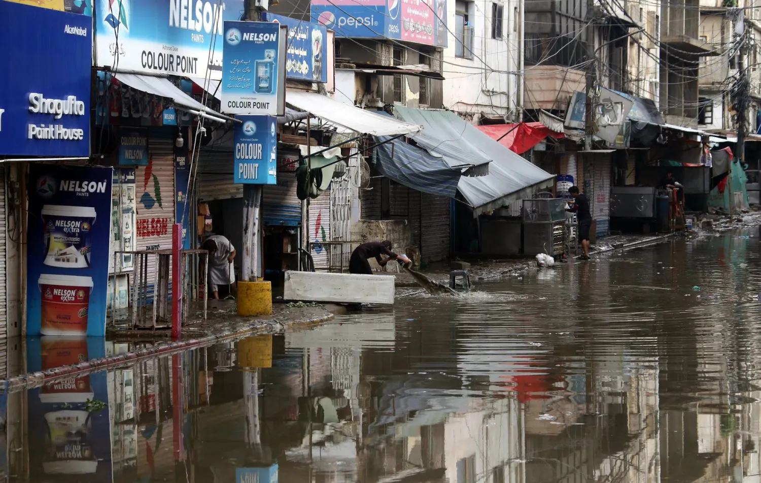 People clear water from a building flooded by heavy rain in Karachi, Pakistan, 20 August 2025. EPA/REHAN KHAN