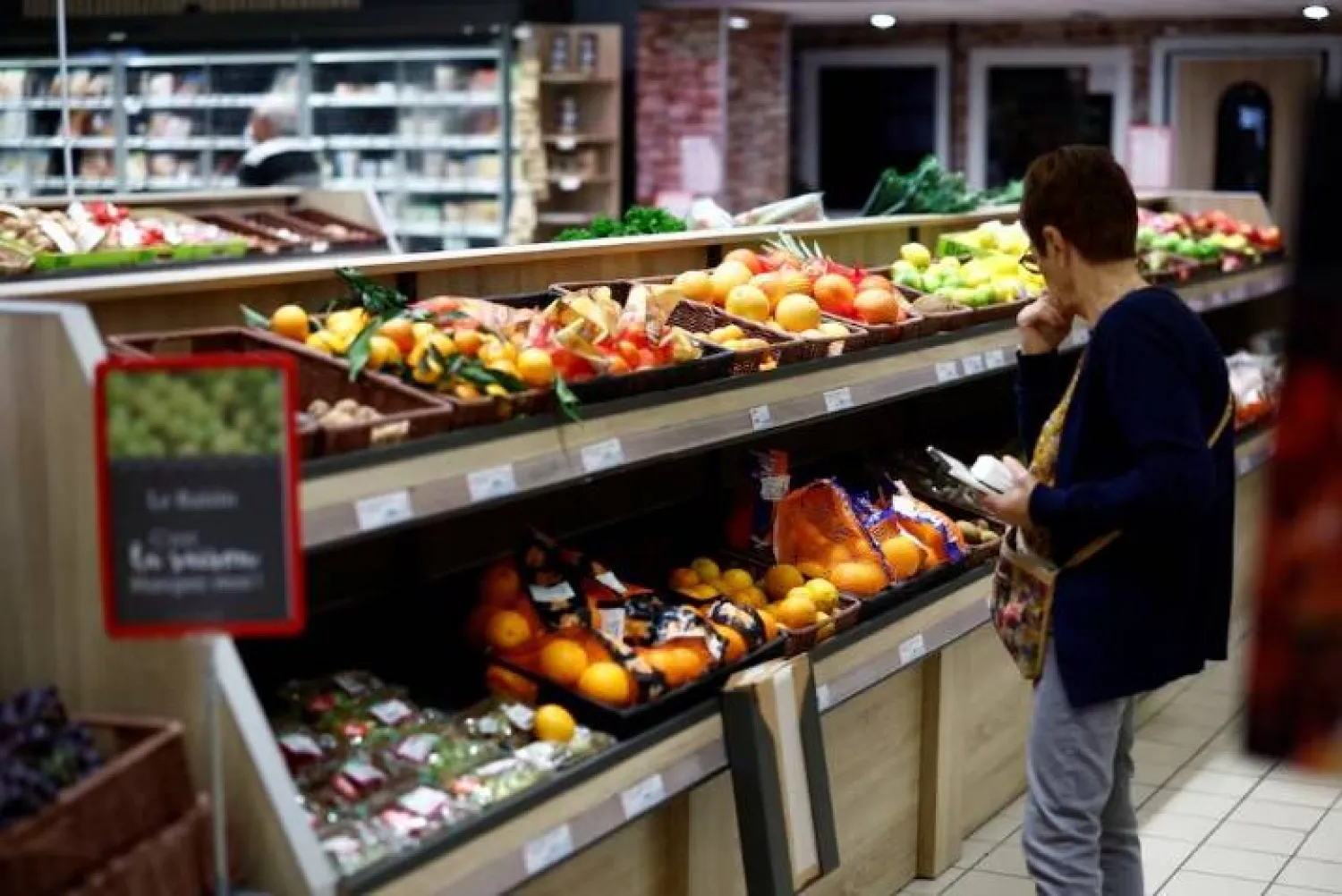 امرأة تتسوق في قسم الفواكه والخضراوات في سوبرماركت بمدينة شانڤري بفرنسا (رويترز)