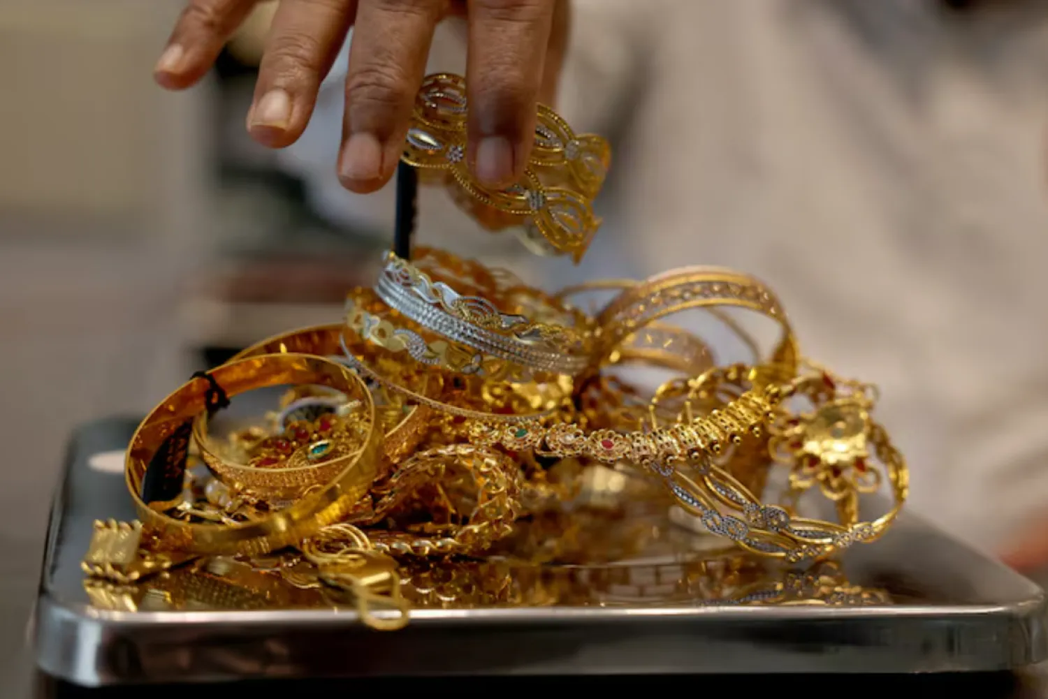 A goldsmith weighs gold jewellery inside a showroom in Ahmedabad, India, July 31, 2025. REUTERS/Amit Dave/File Photo 