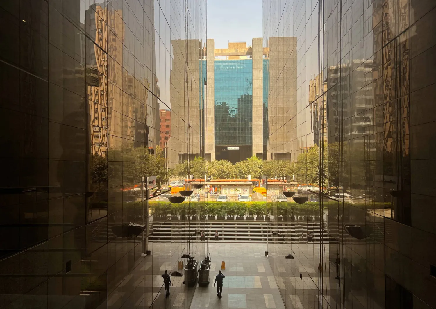 أشخاص يسيرون بين المباني في مركز تجاري في نيودلهي (رويترز)