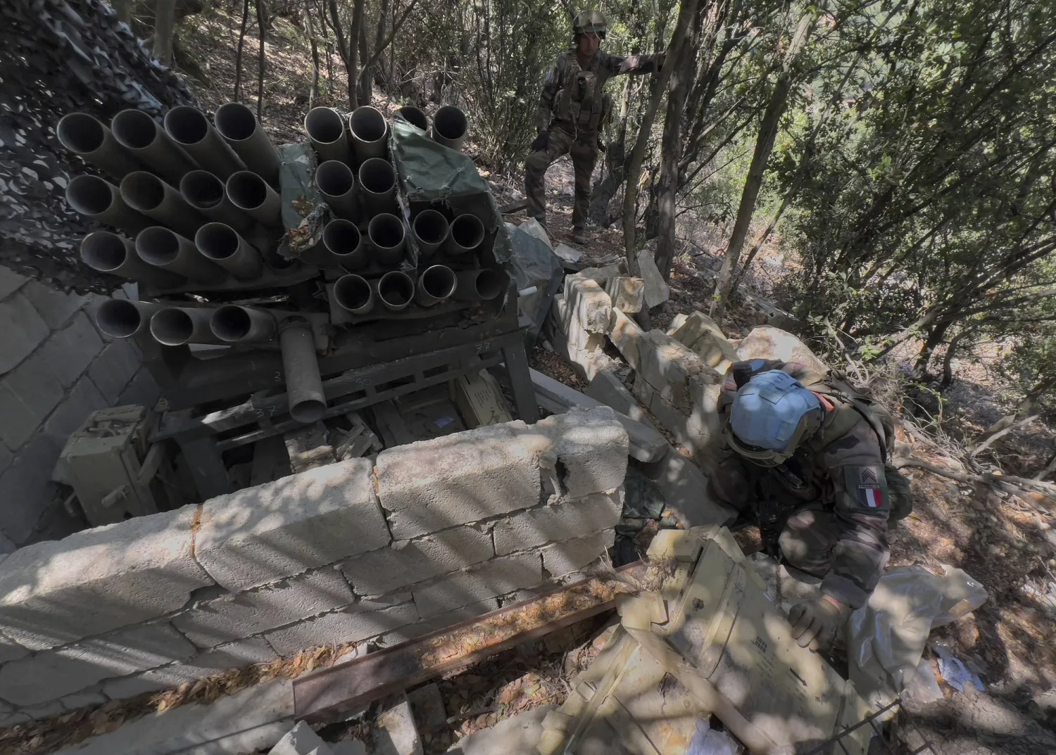 عنصر من الوحدة الفرنسية داخل «يونيفيل» يكشف على صناديق ذخائر في منشأة عسكرية لـ«حزب الله» بجنوب لبنان (أ.ب)