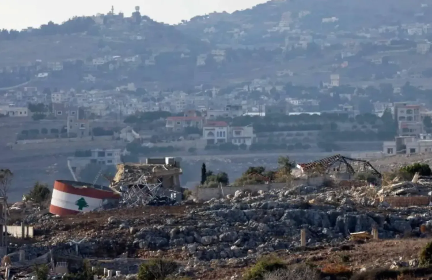 This picture taken from a position in northern Israel, near the border with Lebanon, shows an Israeli flag (L) on a destroyed building, and a Lebanese flag (R) painted on a damaged building in the southern Lebanese village of Mais al-Jabal on November 25, 2024, amid the ongoing war between Israel and Hezbollah. (AFP)