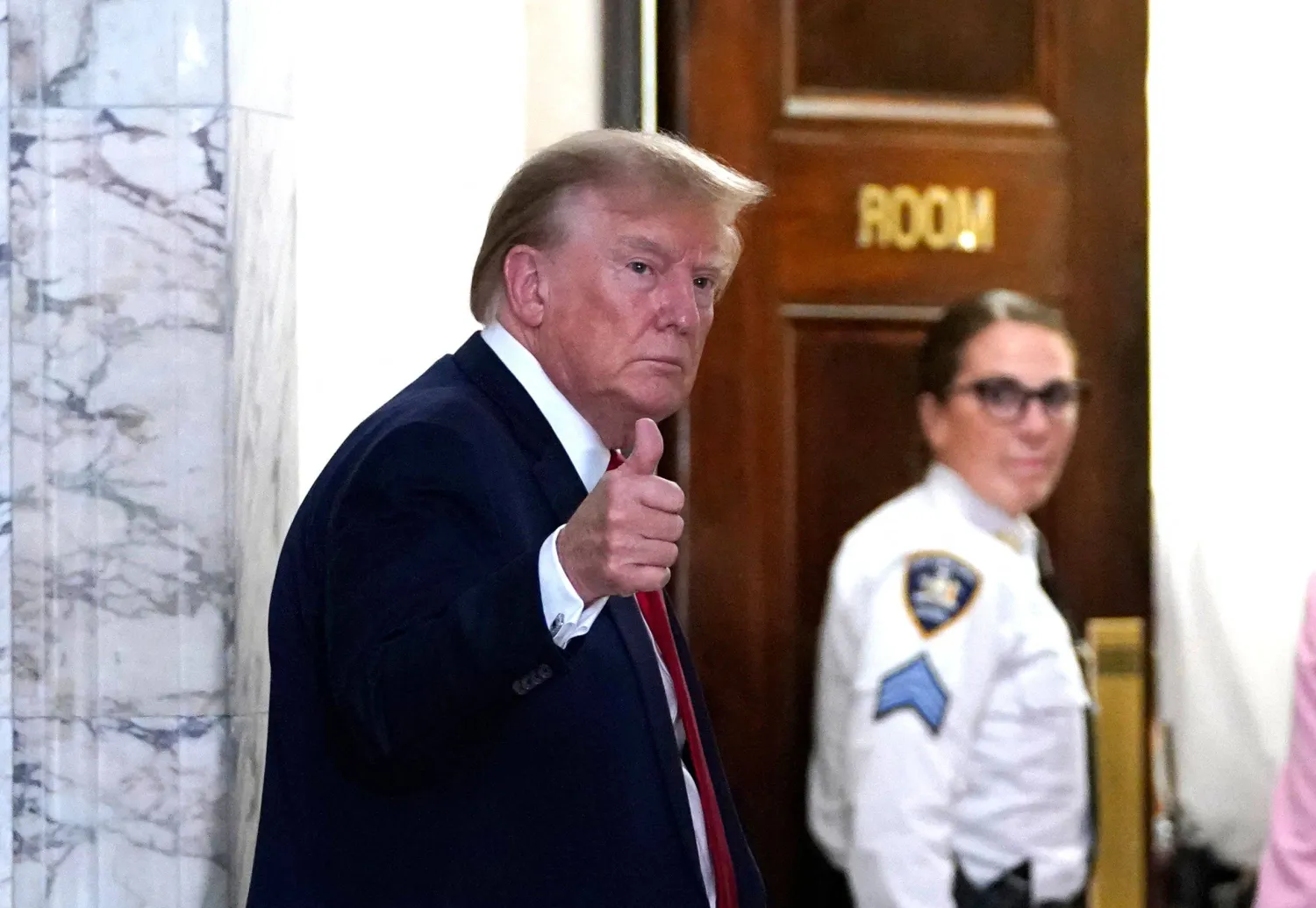 الرئيس الأميركي دونالد ترمب يُشير للصحافيين خلال عودته لقاعة المحكمة في نيويورك يوم 7 ديسمبر 2023 (أ.ف.ب)