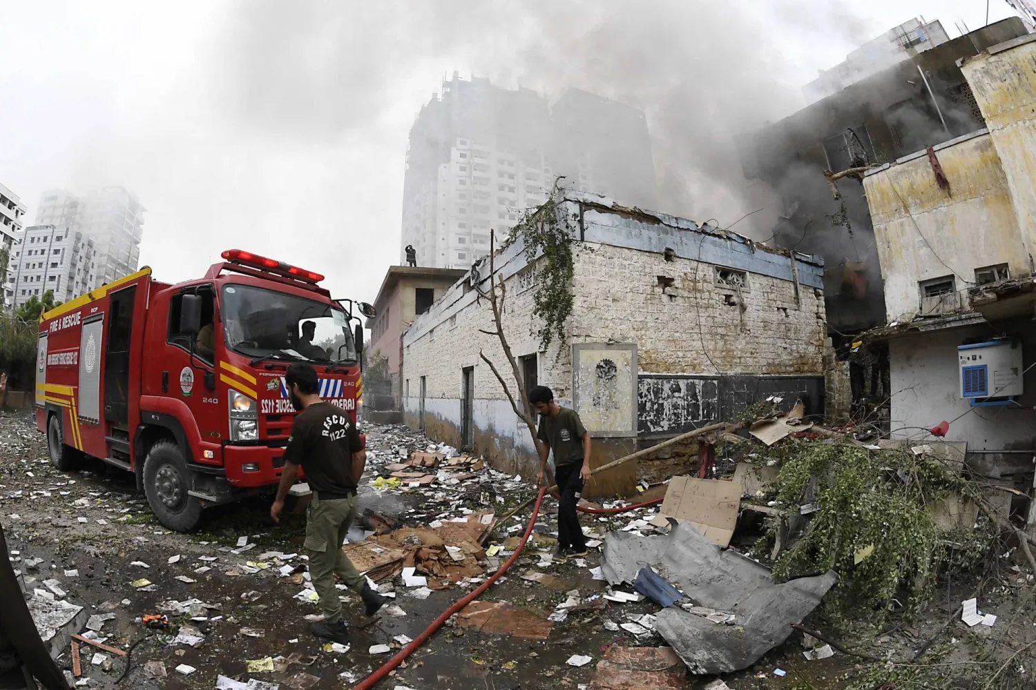 يعمل رجال الإطفاء في موقع حريق اندلع في مصنع للألعاب النارية في كراتشي (إ.ب.أ)