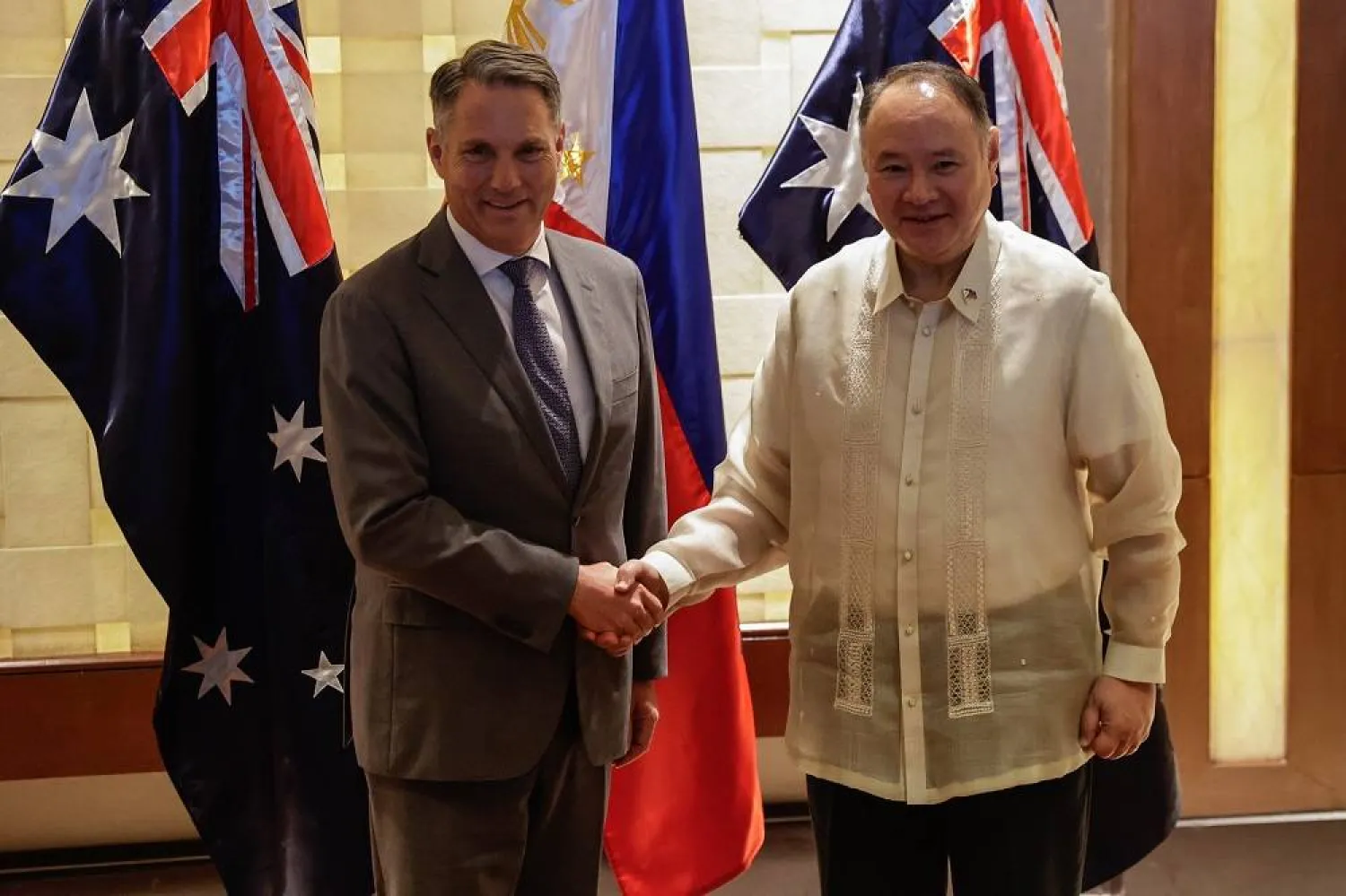 Australian Deputy Prime Minister and Minister for Defense, Richard Marles (L), and Philippine Defense Secretary Gilberto Teodoro (R) shake hands before holding a meeting at a hotel in Makati City, Metro Manila, Philippines, 22 August 2025. (EPA)