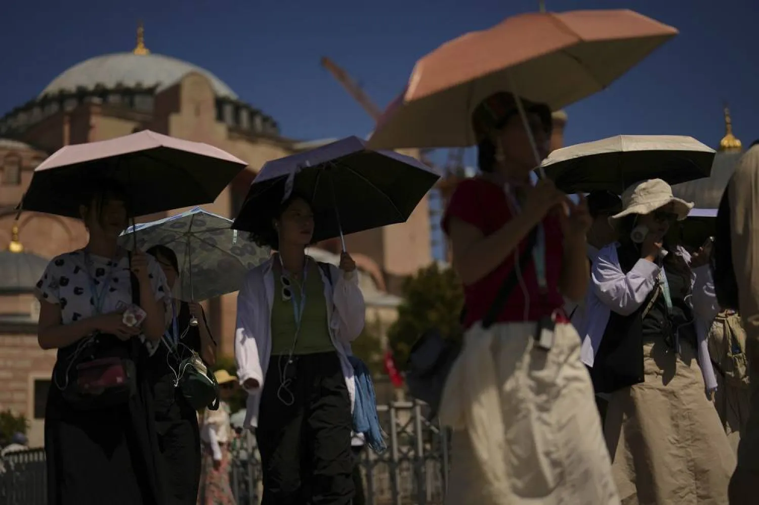 Tourists use umbrellas to shelter against the sun outside Hagia Sophia mosque during a hot summer day in Istanbul, Tuesday, Aug. 12, 2025. (AP) 