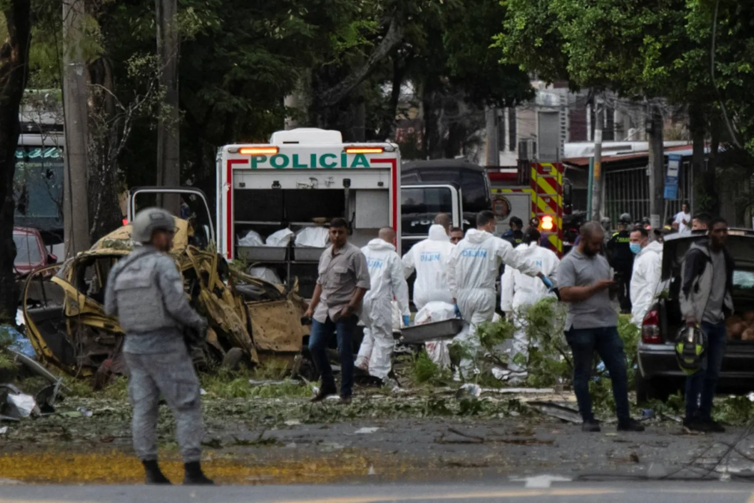 أعضاء فريق الطب الشرعي يزيلون جثة بجوار الحطام في أعقاب انفجار مركبة شحن بالقرب من قاعدة تابعة لقوة الفضاء الكولومبية في أحد الهجومين المنسوبين إلى جماعات منشقة من القوات المسلحة الثورية الكولومبية (فارك) اللذين تسببا في سقوط الكثير من الضحايا (رويترز)